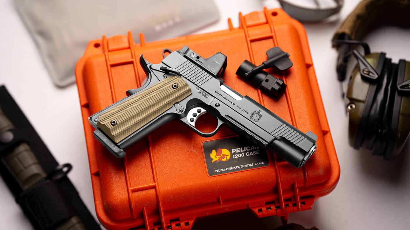 A Springfield Armory 1911 pistol equipped with a mounted red dot sight rests among survival gear and equipment. The 1911 pistol's strengths include adaptability to modern accessories. Optic-ready slides accommodate various sight systems. Red dot sights improve target acquisition speed. Survival applications benefit from proven firearm reliability. The 1911 pistol's weaknesses don't prevent modernization efforts. Added optics increase overall weight slightly. Sight mounting requires proper installation procedures. Springfield Armory offers contemporary 1911 configurations.