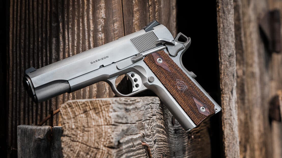 A Springfield Armory Garrison 1911 pistol with a brushed stainless steel finish displayed against a neutral background. M1911 pistols serve as reliable woods guns for outdoor defense. Springfield Armory Garrison represents quality M1911 construction. Stainless steel firearms resist environmental corrosion. Full-size 1911 pistols offer superior handling. The .45 ACP cartridge provides adequate stopping power. Weather-resistant handguns suit backcountry carry. Government model 1911s feature five-inch barrels. Durable sidearms protect against wilderness threats.