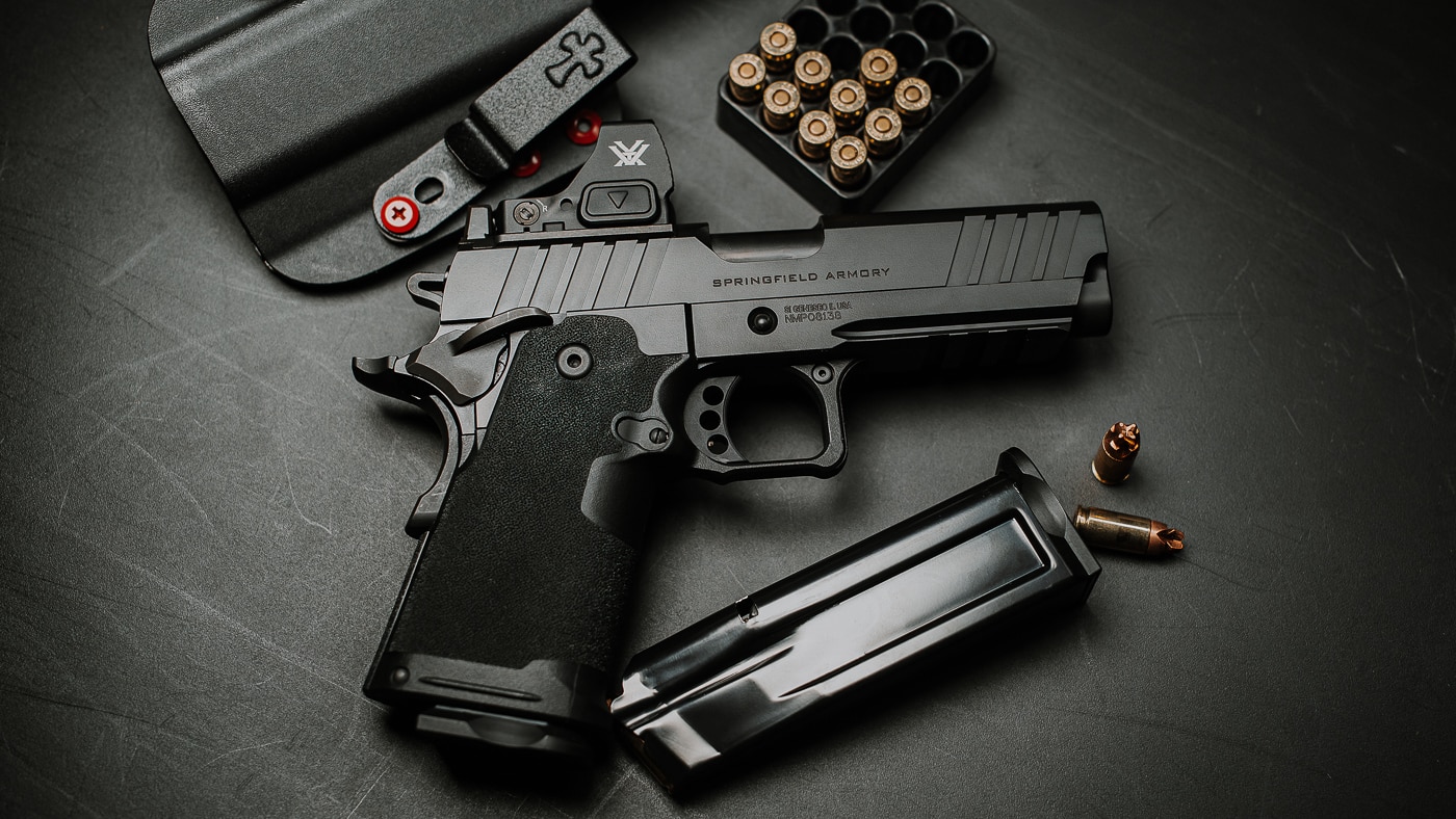 The Springfield Prodigy Compact pistol displayed with a Crossbreed holster and various 9mm ammunition boxes. The Springfield Armory Prodigy Compact review tested multiple ammunition types. This compact 1911 DS functioned reliably with all loads. The Crossbreed Rogue holster provided secure carry options. Federal Premium and Black Hills ammo performed excellently. The Prodigy Compact feeds hollow points without issue. Springfield built this 9mm for ammunition versatility. The pistol cycled over 500 rounds flawlessly. This everyday carry setup proves practical and dependable.