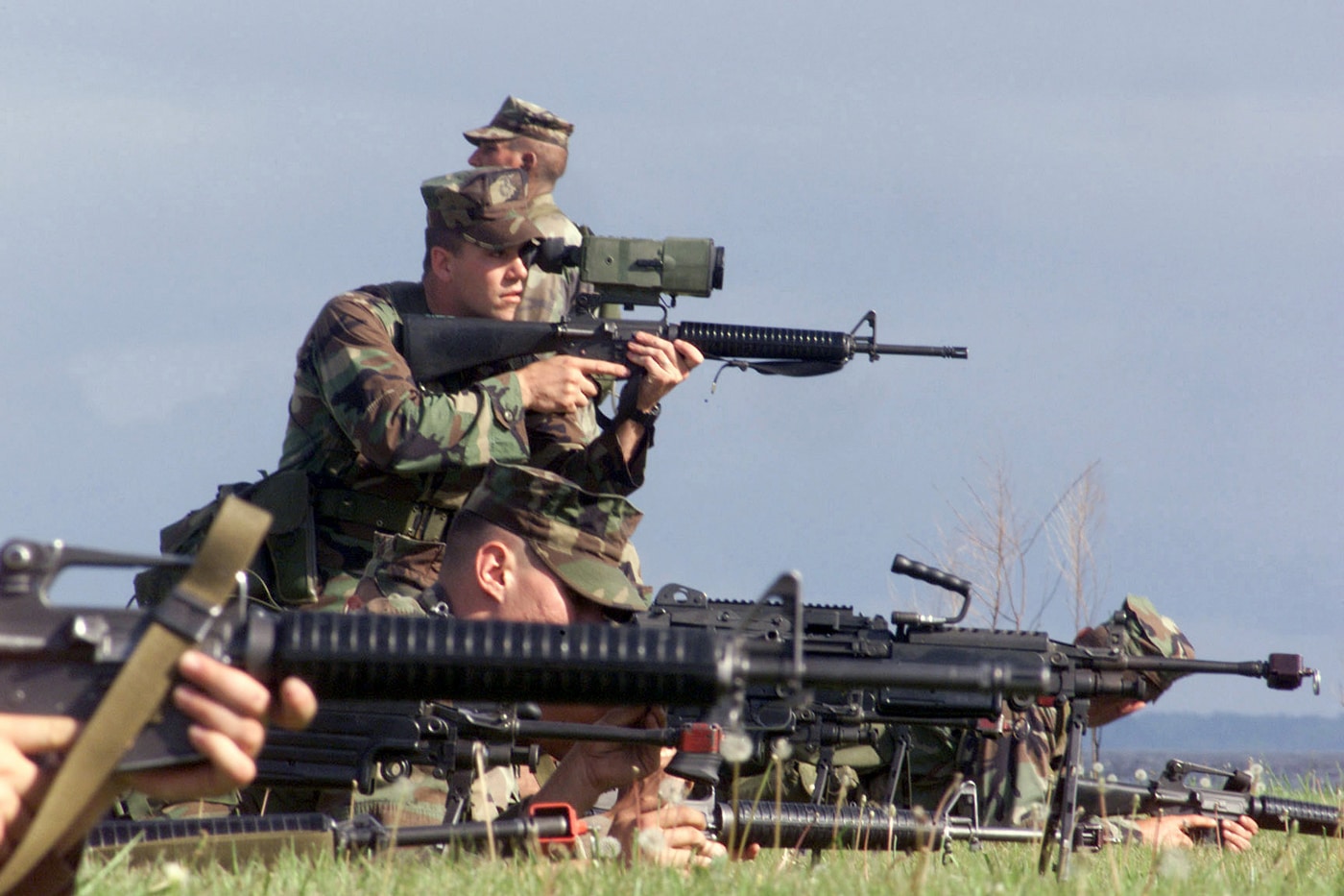 Close view of a Marine training with his M16A2 equipped with bulky thermal scope hardware mounted on the carrying handle in outdoor conditions. The Shinenyx G1A review represents technological miniaturization. Early thermal systems required substantial mounting space. Weapon-mounted optics added significant weight penalties. Shinenyx night vision gear weighs under one pound. Fusion monoculars attach to multiple platforms easily. Compact designs improve operator mobility significantly. Thermal detection ranges exceed 150 yards. Modern devices integrate digital processing capabilities.