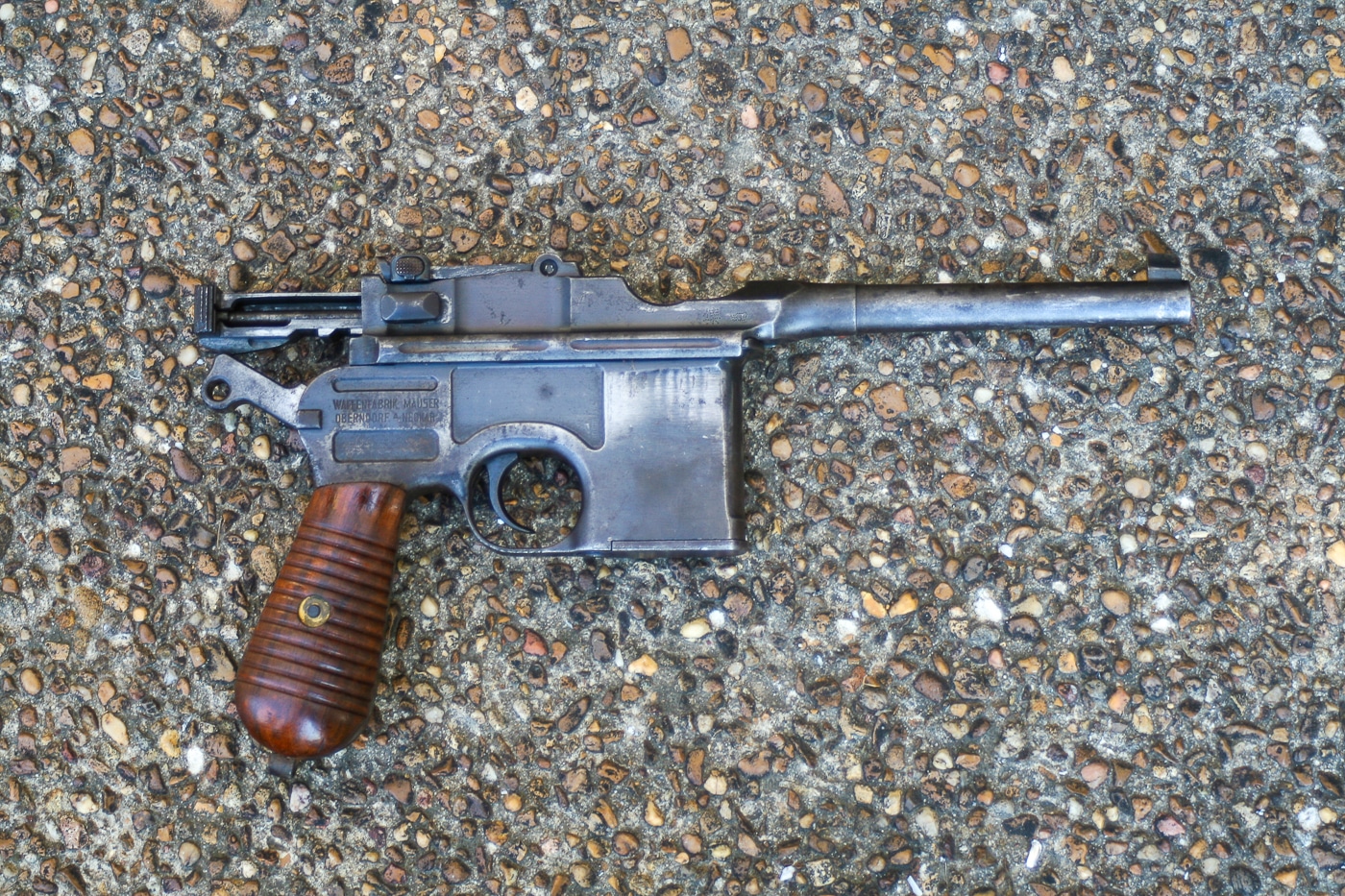A Mauser C96 broomhandle pistol with its distinctive wooden holster-stock combination that served as a shoulder stock, representing an uncommon war trophy from Europe. War souvenirs varied in rarity significantly. Mauser C96 pistols were less commonly encountered. Trophy firearms had different availability levels. Captured broomhandles represented exceptional finds. Military keepsakes ranged from common to scarce. War trophies reflected battlefield circumstances. Seized Mausers symbolized fortunate acquisitions. Trophy weapons demonstrated varying encounter rates.