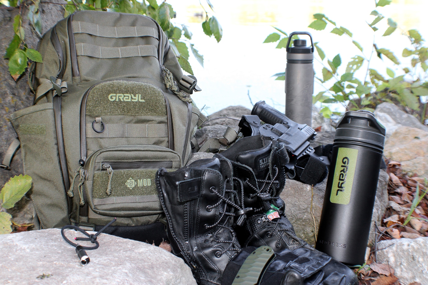 An arranged display shows rugged hiking boots, a tactical daypack, water bottles with purification systems, and a 10mm semi-automatic pistol representing essential backwoods equipment. Backwoods carry kits combine multiple systems. Outdoors survival kits include hydration solutions. Hiking boots provide trail stability. Wilderness firearms offer protection. Water purification ensures safety. Backcountry gear prevents emergencies. Survival equipment supports self-reliance. Outdoor preparedness requires quality tools.