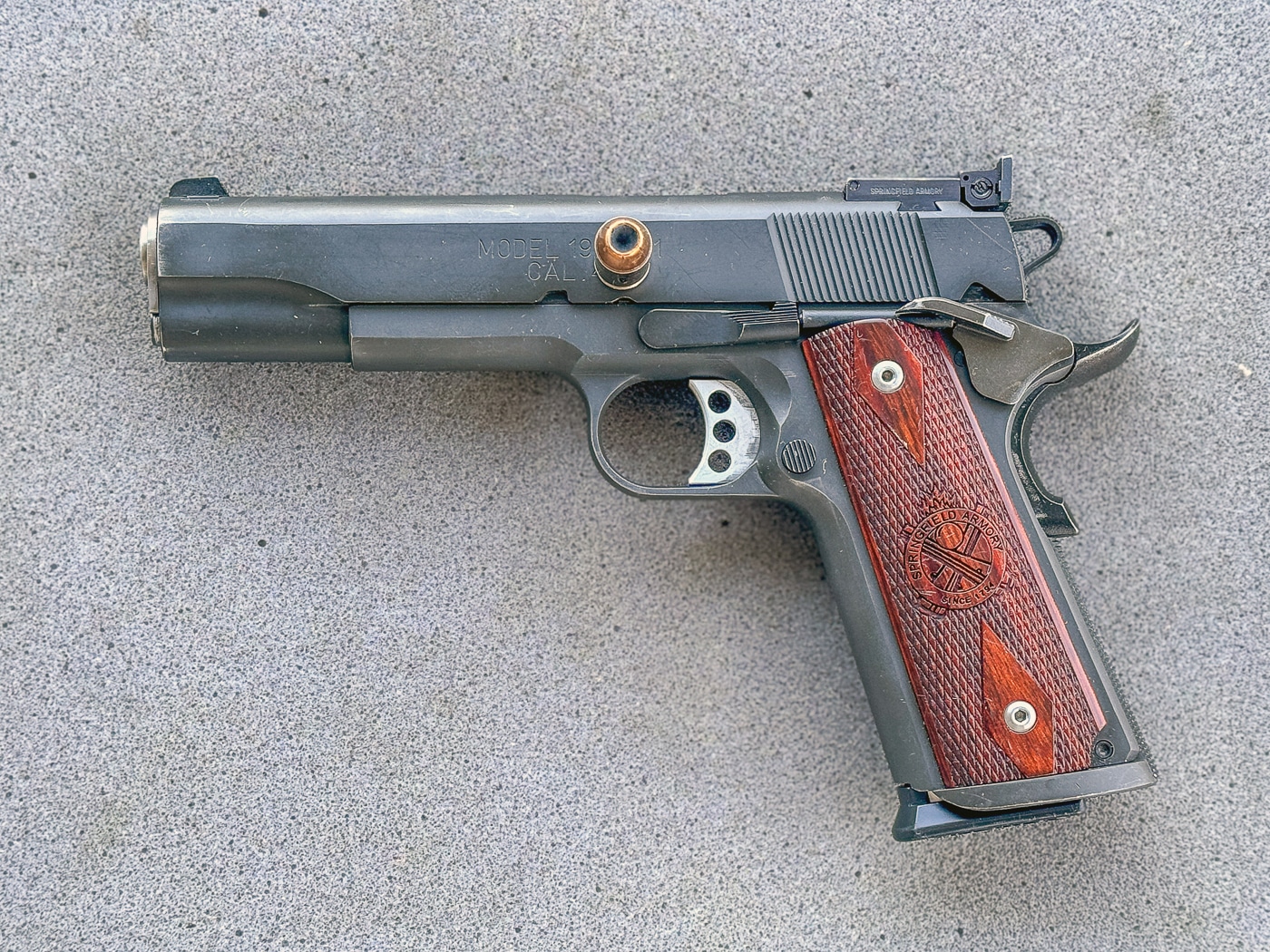 A close-up image shows a 1911 pistol with the hammer lowered onto a chambered round in Condition Two carry mode. The 1911 pistol's strengths don't include Condition Two carry. Hammer-down configurations reduce immediate readiness. Single-action designs require manual cocking before firing. One-handed manipulation proves extremely difficult. The 1911 pistol's weaknesses become apparent in this configuration. Thumb-cocking under stress invites fumbling. Lowering hammers requires trigger pulls on loaded firearms. Drop-safe modern pistols eliminate Condition Two necessity.