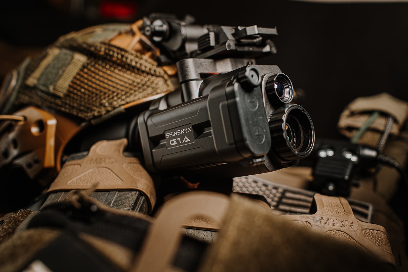 Detailed close-up photograph of the Shinenyx G1A's front sensor housing showing dual lens assemblies, protective construction, and weather-resistant design features. The Shinenyx G1A review examines build quality thoroughly. Dual-sensor housings contain thermal and NV components. Rugged construction withstands demanding field conditions reliably. Shinenyx night vision gear features IPX5 water resistance. Thermal sensors use uncooled microbolometer technology. Digital NV sensors provide 1600x1200 resolution. Field devices require durable protective housings. Seven aspherical lenses ensure optimal image quality.