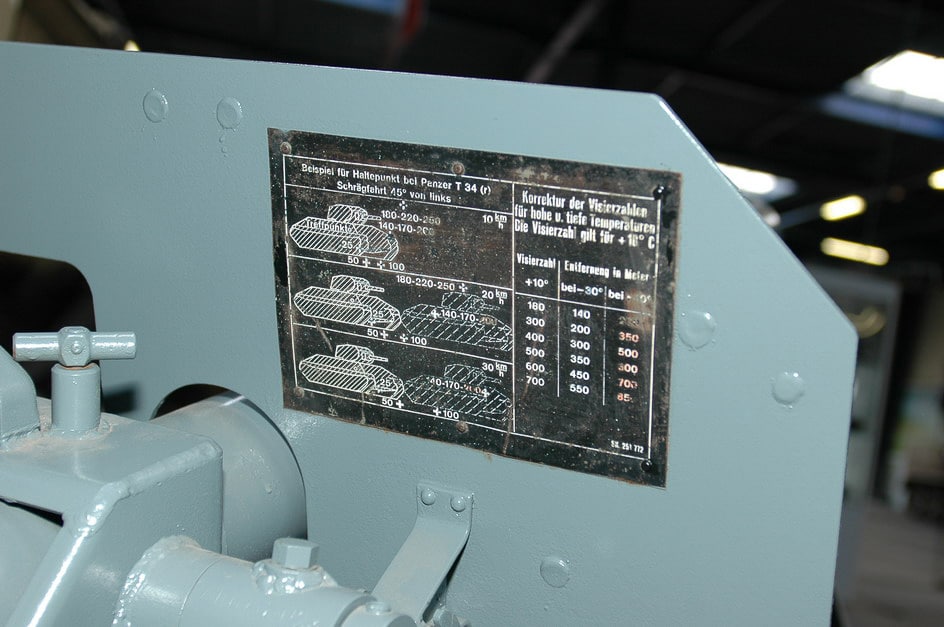 A close-up photograph shows the firing instructions and operational details printed on a plate mounted to the inside of an 8.8cm Raketenwerfer 43 Püppchen gun shield. German weapons included printed firing instructions. The Püppchen shield displayed range tables. Wehrmacht crews referenced onboard operating procedures. The Raketenwerfer 43 featured built-in guidance. German anti-tank gunners used shield-mounted details. Firing data was accessible during combat. The 88mm launcher included crew instructions. Range settings were printed for quick reference.