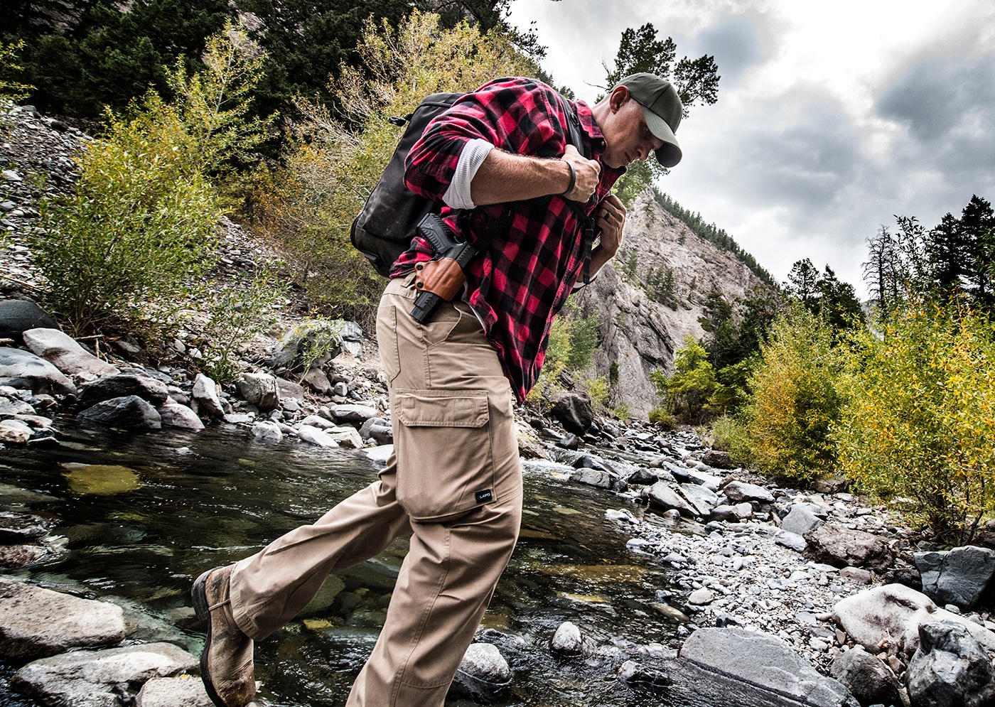 A backwoods traveler showcases their complete survival and defensive carry setup including firearms, water purification systems, fire-starting tools, medical supplies, and navigation equipment. Backwoods carry kits balance weight and capability. Outdoors survival kits integrate multiple systems. Wilderness carry setups include medical provisions. Backcountry equipment serves essential functions. Hiking safety requires comprehensive gear. Survival preparedness involves training. Remote location kits provide security. Outdoor readiness systems sustain adventurers.