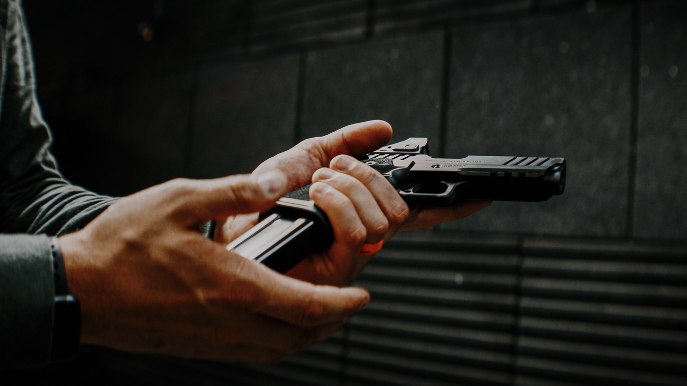 A shooter loads a fresh magazine into the Springfield Prodigy Compact pistol during range testing. The Springfield Armory Prodigy Compact review evaluated magazine reliability. This compact 1911 DS accepts double-stack 15-round magazines. The pistol comes with two flush-fitting mags included. Springfield offers extended 26-round magazines as well. The Prodigy Compact's magazine well allows smooth insertion. Magazines dropped free consistently during reload drills. This 9mm compact handles reloads quickly and efficiently. The double-stack design increases ammunition capacity significantly.