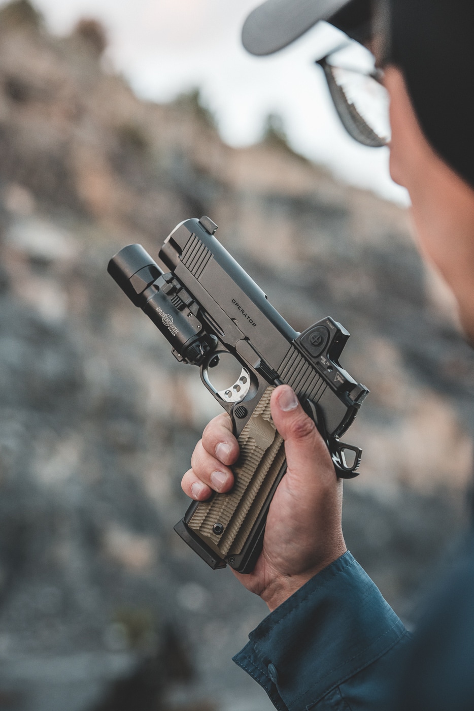 A photograph shows a man holding a Springfield Armory 1911 pistol with proper firing grip and thumb positioned on the safety lever. The 1911 pistol's strengths include superior ergonomic design. Natural grip angle promotes instinctive pointing ability. Single-stack frames fit various hand sizes. Thumb safety placement allows easy manipulation. The 1911 pistol's weaknesses require dedicated handling practice. Grip safety activation needs proper hand placement. Manual controls demand muscle memory development. Experienced shooters appreciate traditional handgun platforms.