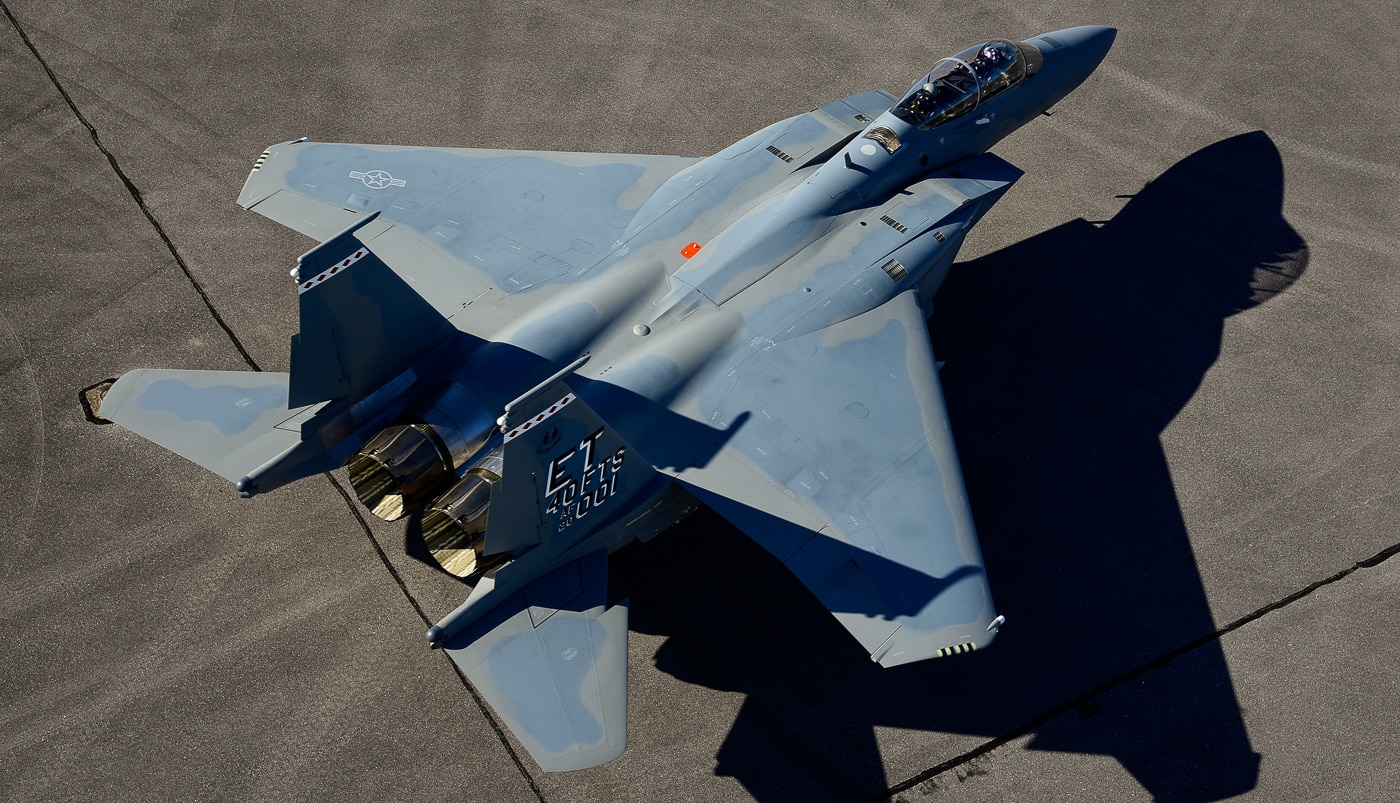 An overhead view captures the F-15EX Eagle II on the ground at Eglin Air Force Base, revealing the fighter's twin-engine layout, conformal fuel tanks, and expansive weapons stations from above. The Eagle II features a strengthened airframe design. Conformal fuel tanks extend the fighter's range. Boeing engineered multiple hardpoints for ordnance. The twin-tail configuration provides stability at high speeds. Sensor systems integrate along the fuselage. The F-15EX carries 28% more payload than the Strike Eagle. Eglin AFB ground crews service the aircraft. The overhead angle shows weapons mounting positions.