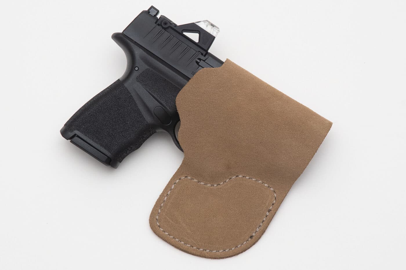 A Springfield Hellcat 380 ACP pistol sits in or near a dress pants pocket, demonstrating compact dimensions suitable for discrete workplace carry. Concealed carry at work utilizes pocket holsters. Workplace CCW benefits from compact firearms. Office carry demands small defensive pistols. CCW at the office uses business casual pockets. Professional concealment requires mouse guns. Business attire accommodates pocket carry. Concealed carry at work means instant access. Office defense includes subcompact handguns.