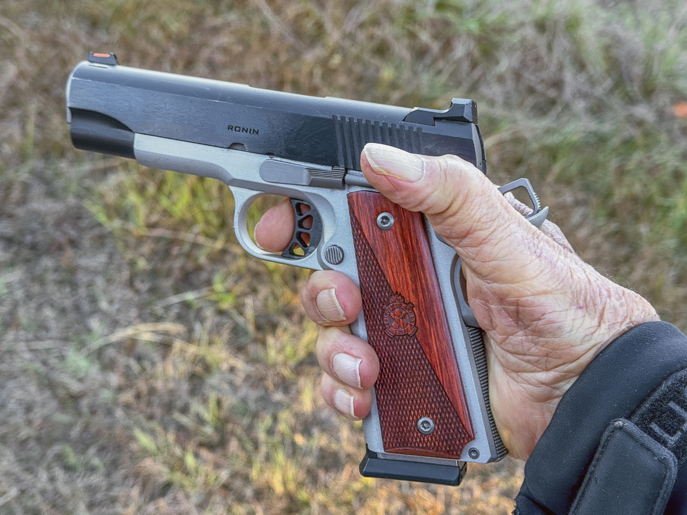 A close-up photograph shows a 1911 pistol's compact trigger guard with limited clearance space for finger access. The 1911 pistol's strengths don't include generous trigger guard dimensions. Traditional designs accommodated bare-handed shooting only. Modern tactical gloves reduce trigger accessibility. Compact guards reflect early 20th-century requirements. The 1911 pistol's weaknesses include cold-weather operation challenges. Gloved fingers struggle entering narrow trigger guards. Tactical shooters prefer enlarged guard openings. Contemporary pistols feature undercut trigger guards.