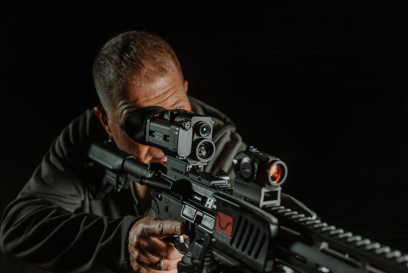 The Shinenyx G1A monocular mounted on a rifle's picatinny rail behind a red dot sight showing the compact profile and positioning relative to the primary optic. Shinenyx G1A review examines weapon-mounting configurations thoroughly. Behind-optic mounting preserves shooting stance naturally. The G1A aligns with existing sight systems. Shinenyx night vision gear attaches to picatinny rails securely. Thermal monoculars augment primary optics effectively. Shooters maintain familiar cheek weld positions. Fusion devices provide target detection advantages. Weapon configurations remain ergonomically optimized.