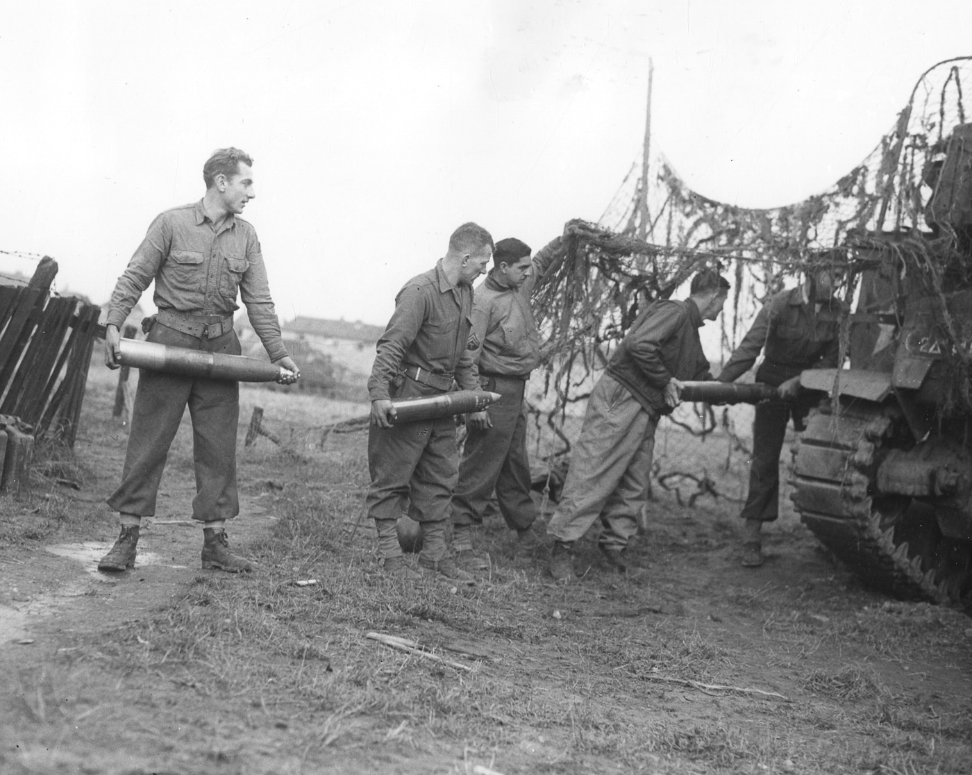 American soldiers load 105 mm artillery shells into their M7 Priest near the Siegfried Line