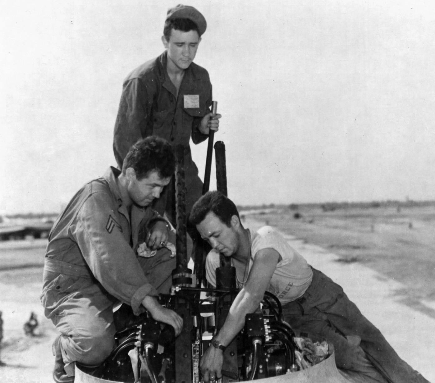 B-29 ground crew services a remote controlled gun turret at an air base in India