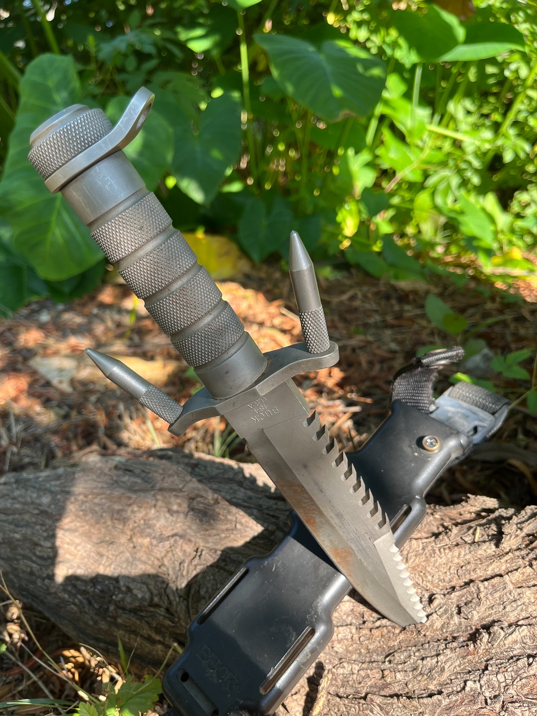 A Buck brand fighting knife from the 1980s featuring a serrated spine, hollow handle, and clip point blade design popular during that decade. Fieldcraft knives evolved through design experimentation. Survival knife trends influenced blade development. Dale Dye field craft knife opinions learned from impractical designs.