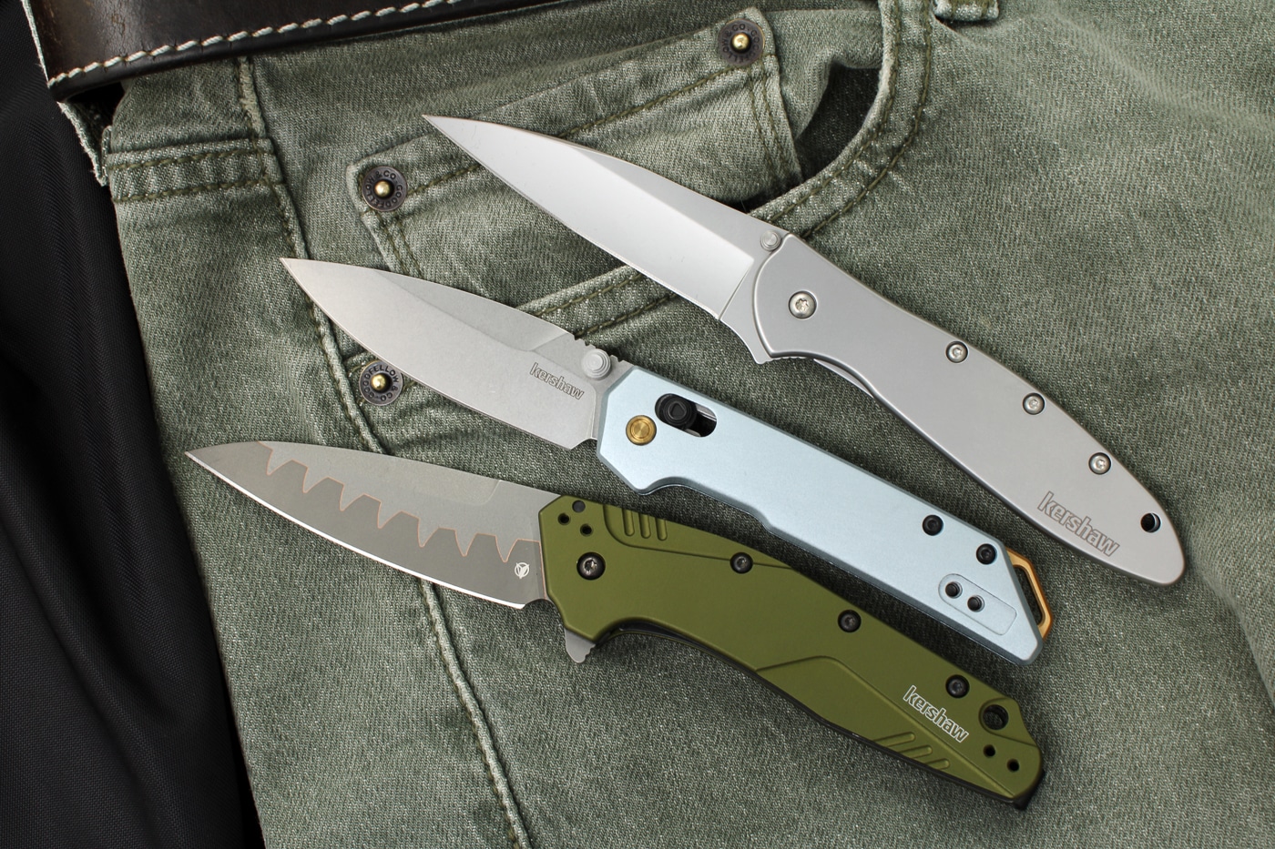 The photograph shows multiple Kershaw pocket knives with their blades fully opened, revealing the various blade shapes, grinds, and steel types used in the manufacturer's designs. Kershaw knives feature different blade geometries for specific tasks. Hollow-ground edges excel at slicing performance. Affordable knives benefit from thin blade stock. Spear point designs offer enhanced tip strength. Kershaw models utilize 14C28N Swedish steel. Drop point blades provide versatile cutting profiles. Affordable knives incorporate modern grinding techniques. Factory edge sharpness rivals custom knifemaker quality.