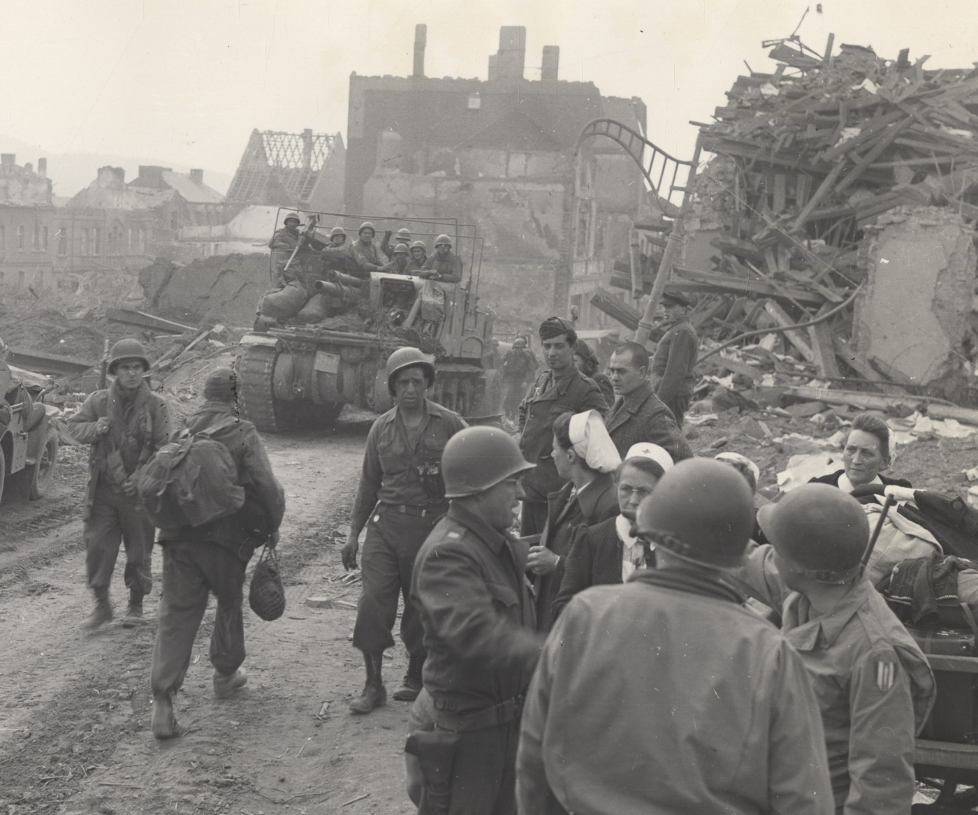 An M7 Priest self-propelled artillery vehicle from the 3rd Armored Division moving along a road near Eichelhardt, Germany during World War II operations. The M7 Priest maintained operational tempo with armored units. Self propelled artillery traversed European terrain effectively. Tracked vehicles negotiated damaged roads. Mobile howitzers supported advancing formations.