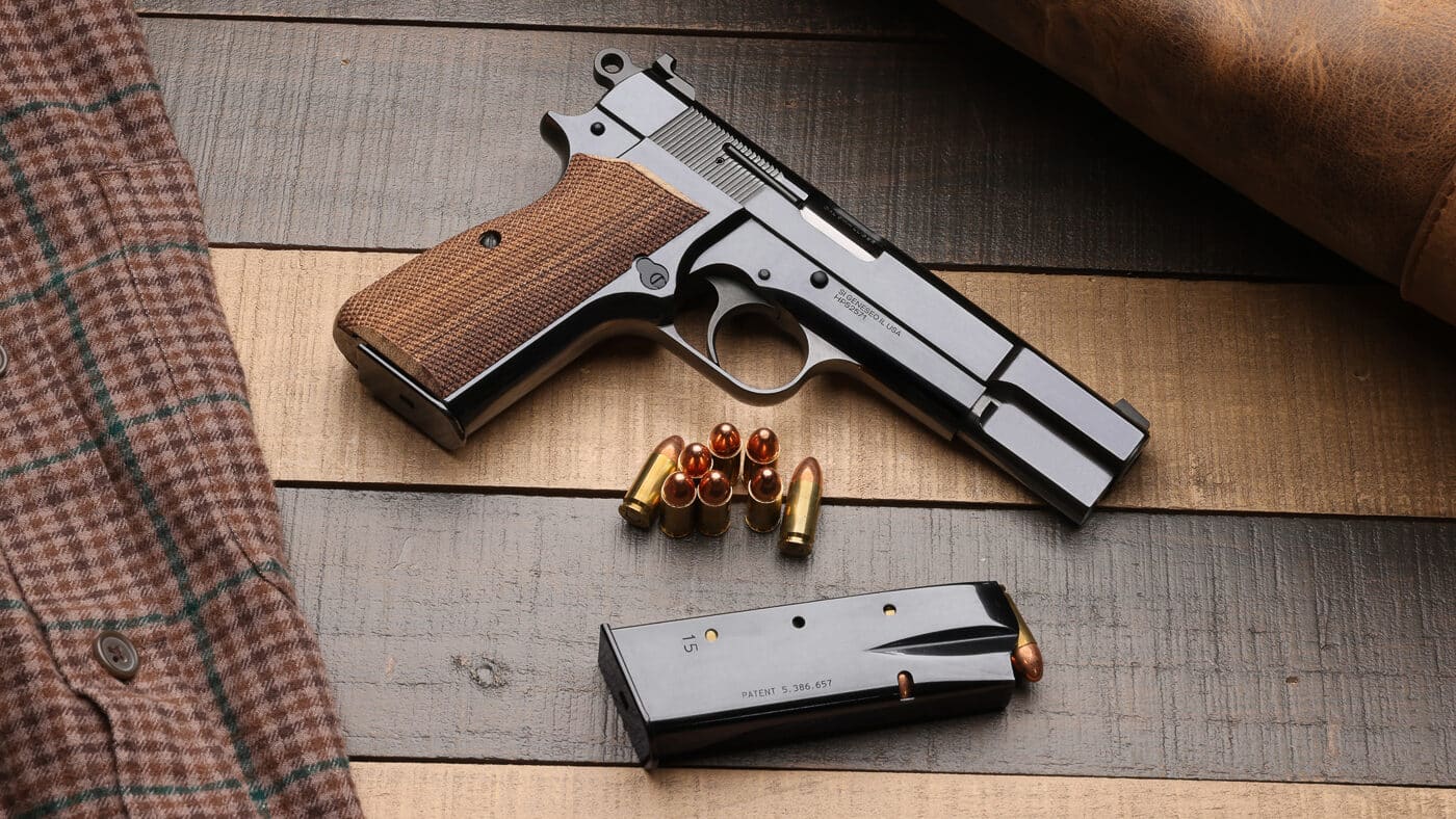 A Springfield Armory SA-35 pistol with a highly polished blue finish displayed against a neutral background, showing the gun's reflective surface and classic profile. The Polished Blued Springfield Armory SA-35 features mirror-like craftsmanship. High polish blue SA-35 models showcase premium gunmaking. Burnished finishes evoke heirloom-quality firearms. The SA-35 9mm utilizes Browning's P-35 design. Single-action pistols offer precise trigger control. Staggered magazines hold thirteen rounds. Cold hammer forged barrels ensure accuracy. Tactical Rack sights modernize classic handguns.