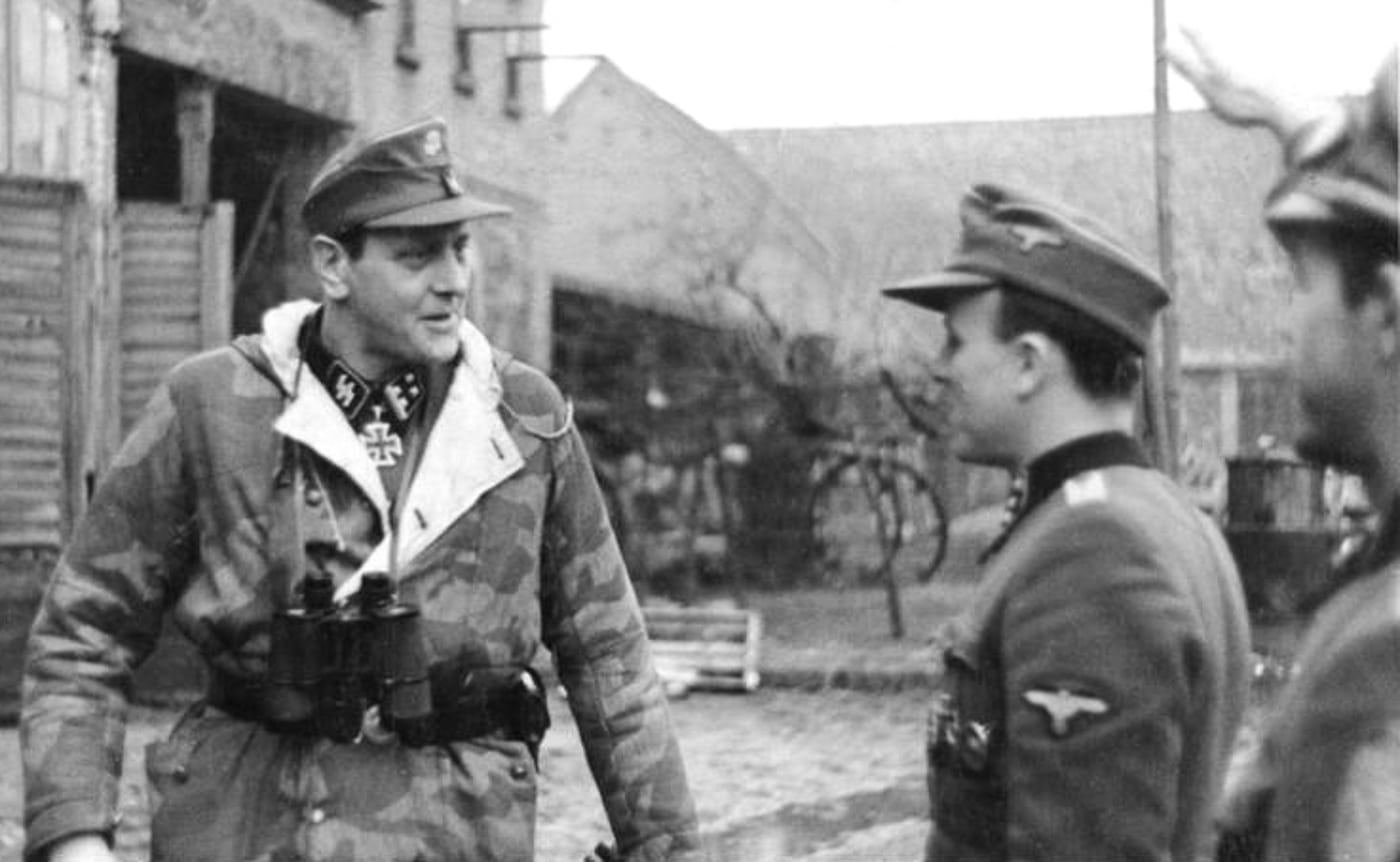 Black and white photograph of SS Obersturmbannführer Otto Skorzeny in military uniform, showing his tall frame and the prominent dueling scar across his left cheek that made him instantly recognizable. SS Obersturmbannführer Otto Skorzeny commanded special operations. German commandos conducted covert missions. Skorzeny valued suppressed Sten Mk IIS firearms. Elite units required stealthy weapons. The German officer demonstrated silenced SMGs publicly. Special forces tactics evolved during WWII. Suppressed 9mm submachine guns enabled clandestine operations. Skorzeny influenced modern special operations doctrine.