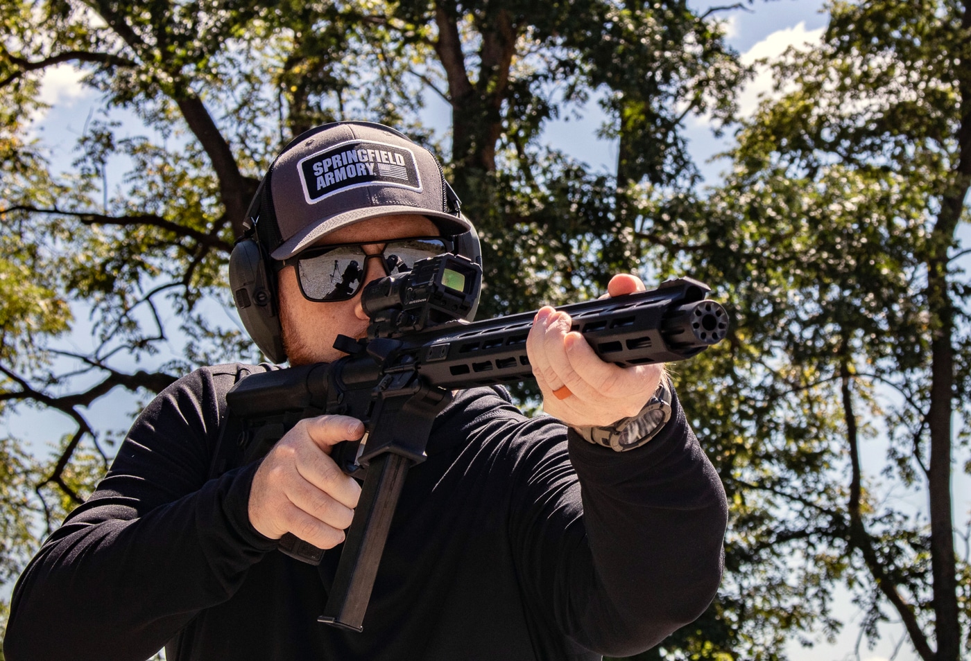 A Springfield Armory SAINT Victor 9mm carbine and Hellcat Pro pistol are photographed with spent brass and loaded magazines nearby. Speer Gold Dot Carbine ammunition delivered 100-percent reliability. PCC ammo maintains functionality across barrel lengths. The sealed primers ensure dependable ignition. Gold Dot loads fed flawlessly through both firearms. Pistol caliber carbines benefit from proven handgun ammunition. The Speer Gold Dot Carbine review experienced zero cycling issues. Carbine ammunition works in defensive pistols equally well. Springfield Armory platforms accepted Speer loads without hesitation.