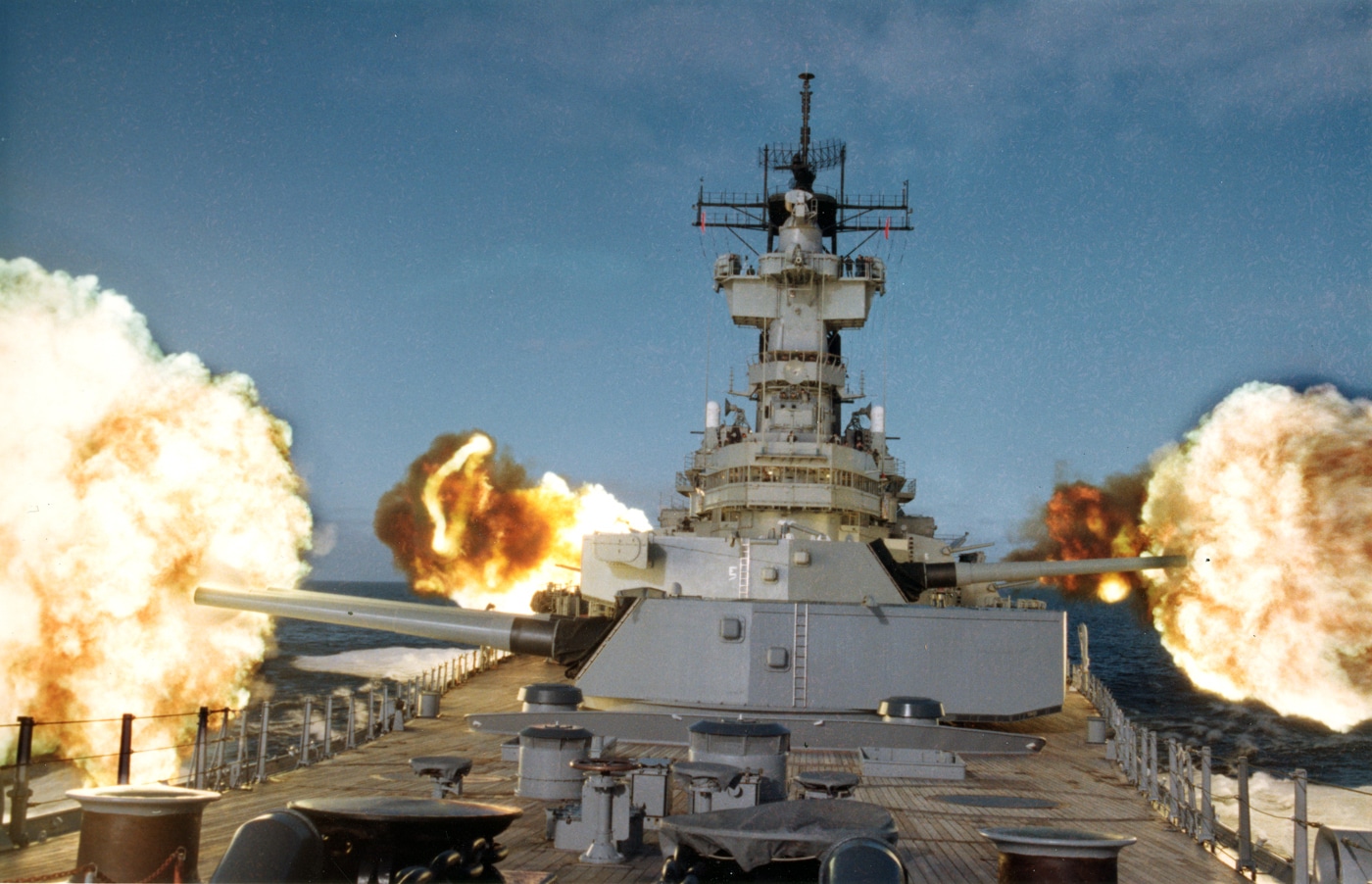 A photograph captures USS New Jersey firing both its massive 16-inch main guns and smaller 5-inch secondary guns simultaneously in the northern Pacific Ocean, with smoke and fire erupting from multiple gun positions across the battleship's superstructure and turrets. Mark 7 guns previously fired Mark 23 nuclear shells. Project Katie armed USS New Jersey with atomic projectiles. Main battery guns achieved 24-mile engagement ranges. Secondary batteries provided additional firepower coverage. USS New Jersey combined multiple weapons systems. Iowa-class battleships mounted nine 16-inch guns. Five-inch guns complemented main armament capabilities. Full battery exercises demonstrated combat readiness.