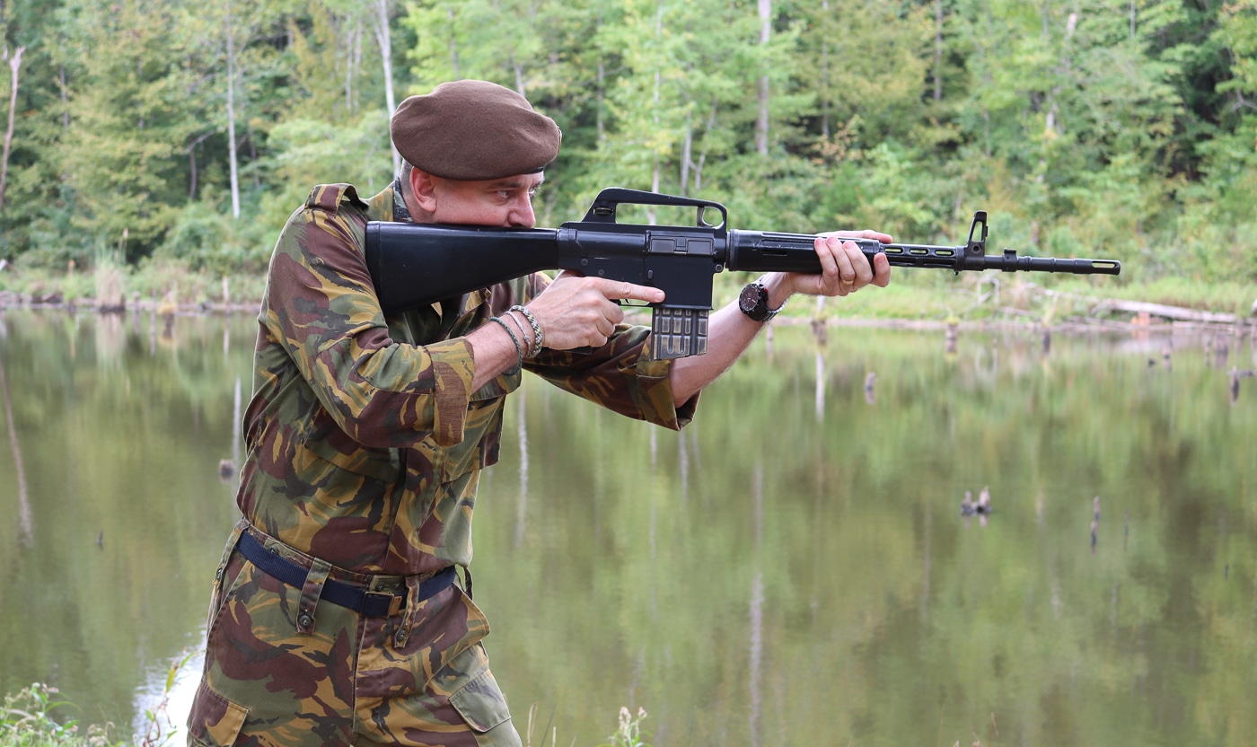 A firearms enthusiast engaging targets with an authentic Dutch AR-10, illustrating the timeless effectiveness of Stoner's innovative direct gas impingement system and inline design geometry. The AR-10 shoots accurately. Dutch examples exhibit craftsmanship. Stoner's innovations endure testing. AR10 history encompasses battlefield success. The rifle cycles reliably. Hard-chromed components resist wear. Portuguese troops praised performance. Modern shooters appreciate originals.