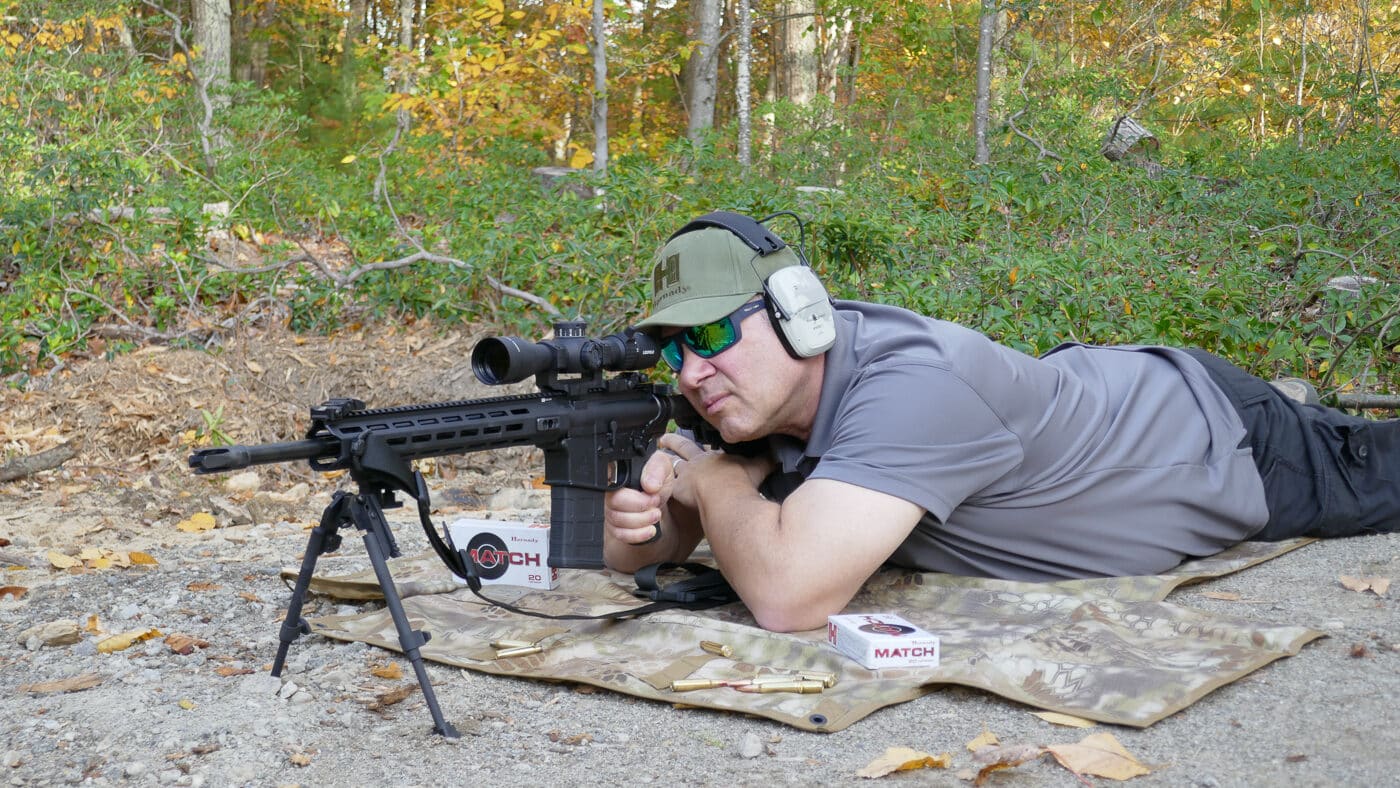 A shooter in tactical gear engaging targets with a Springfield Armory SAINT Victor 7.62x51mm rifle equipped with a magnified optic, demonstrating proper shooting form and rifle handling technique. The SAINT Victor 7.62 20-inch excels during practical evaluation. Springfield rifles demonstrate consistent field accuracy.
