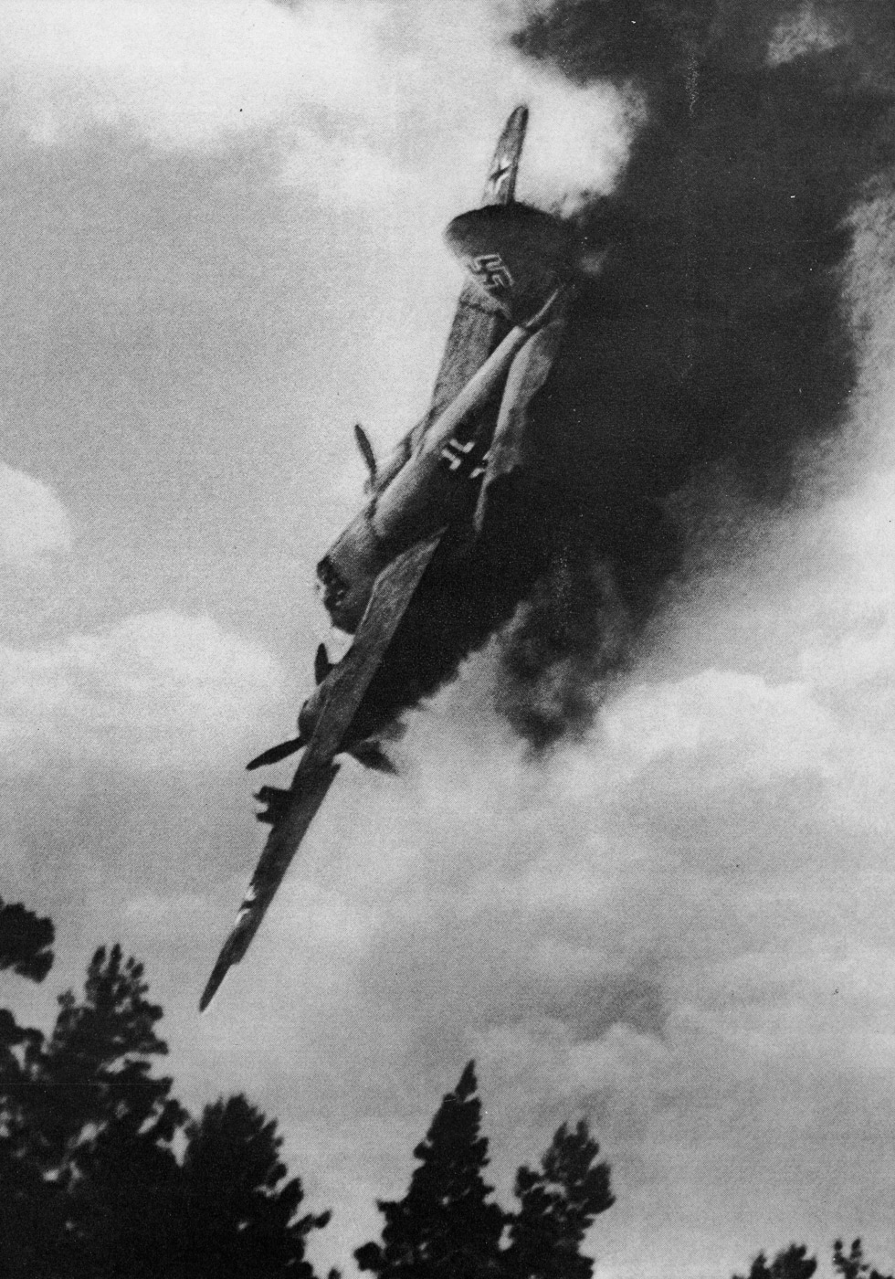 A doomed Ju 88 engulfed in flames and losing altitude after being hit during a combat mission. Germany's Ju 88 bomber suffered high casualty rates. Enemy fighters targeted twin-engine bombers aggressively. Aircraft fires spread rapidly through fuel systems. Combat damage compromised flight control surfaces. Luftwaffe losses mounted during offensive operations. Defensive armament proved insufficient against determined attacks. Crew escape possibilities diminished with catastrophic damage. Historical images preserve combat action moments.