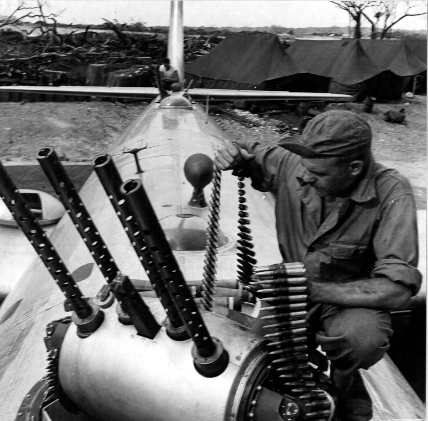 crewman loads 50-caliber ammunition in the quad turret of a B-29
