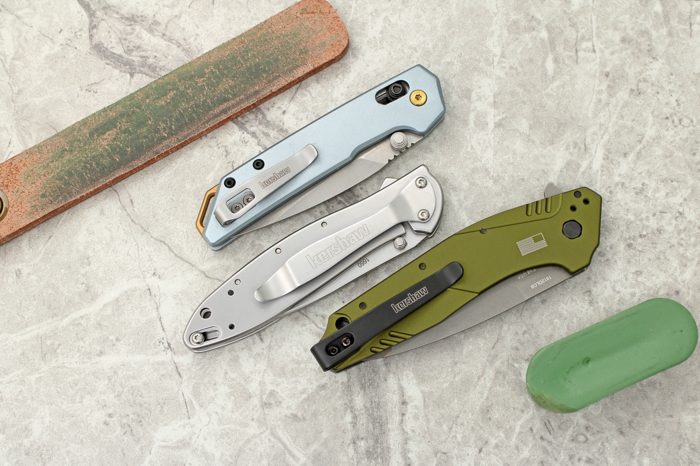 Three distinct Kershaw pocket knife models are arranged together, each showcasing different blade styles and handle materials from the manufacturer's lineup. Kershaw knives represent American cutlery innovation. Budget folders deliver premium cutting performance. The company evolved from back lock designs. Affordable knives incorporate crossbar locking mechanisms. Kershaw products feature aluminum handle construction. Modern EDC knives prioritize pocket-friendly dimensions. The brand offers Swedish 14C28N steel. Affordable knives benefit from factory hollow grinds.