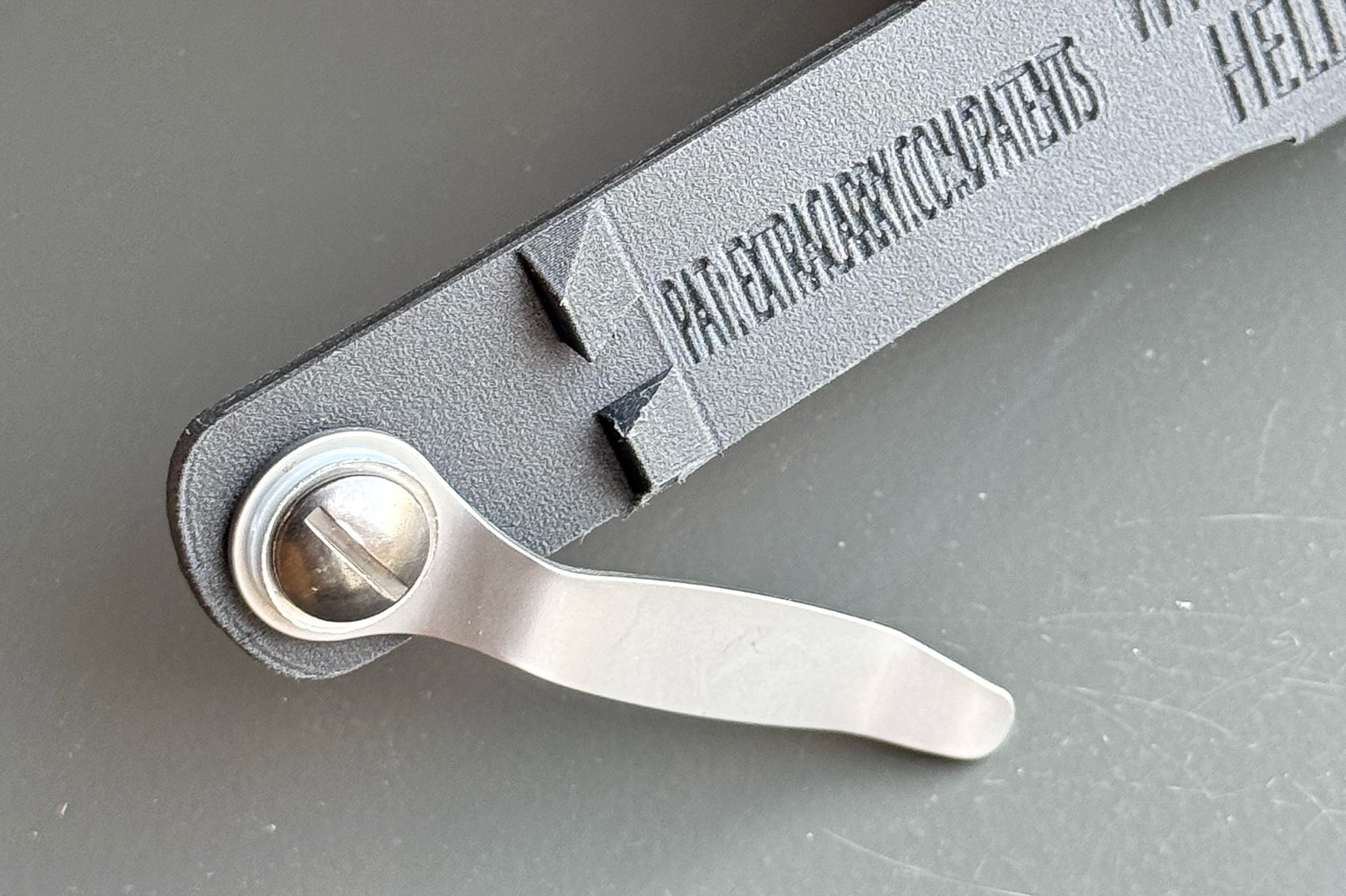 Close-up view of the ExtraCarry magazine pouch reveals two small notches molded into the body beneath the clip, designed to catch pocket fabric and prevent unintended extraction. ExtraCarry reviews highlight retention features. Magazine carriers require anti-pull design. Concealment pouches incorporate functional details.