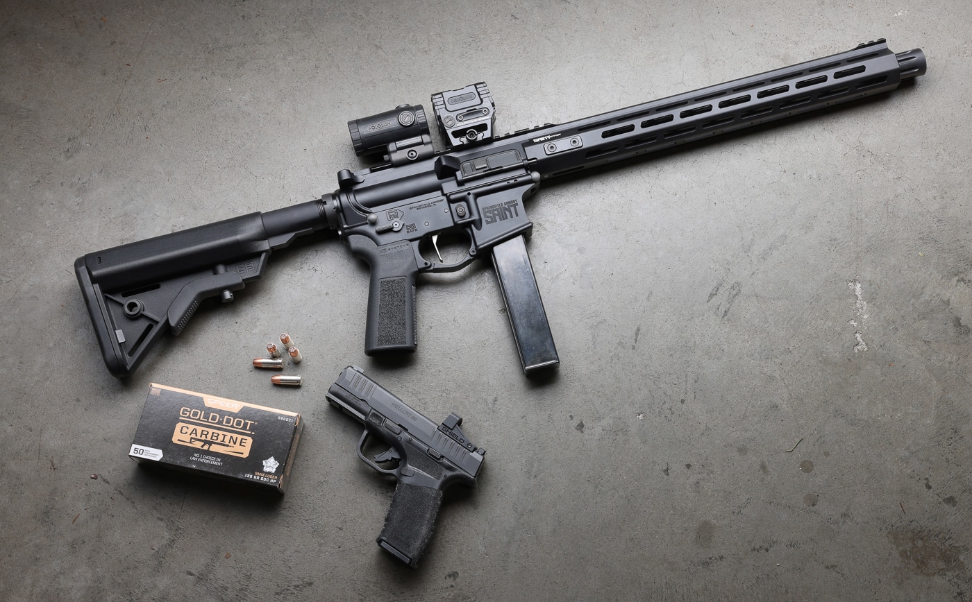 Close-up view displays Speer Gold Dot Carbine cartridges with visible hollow-point cavities and brass casings. The Speer Gold Dot Carbine review examines terminal ballistics. PCC ammo benefits from electrochemical bonding technology. Gold Dot G2 bullets contain specialized elastomer filling. Carbine loads prevent jacket-core separation on impact. The 9mm Gold Dot Carbine penetrates 19 inches in gel. Pistol caliber carbines offer reduced recoil compared to rifles. Speer ammunition achieves low standard deviation in velocity. Nickel plating enhances feeding reliability in semi-automatics.