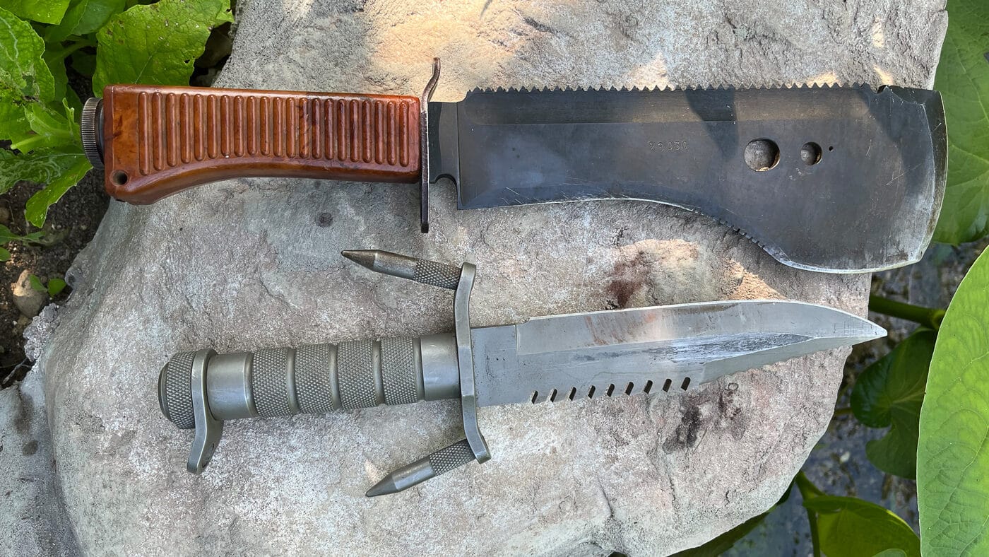 A display of two tactical fixed-blade knives representing essential gear for serious wilderness work and military-style field training. Fieldcraft knives combine utility with durability. Proper blade selection matters for outdoor professionals. Dale Dye field craft knife opinions stress function over flash.