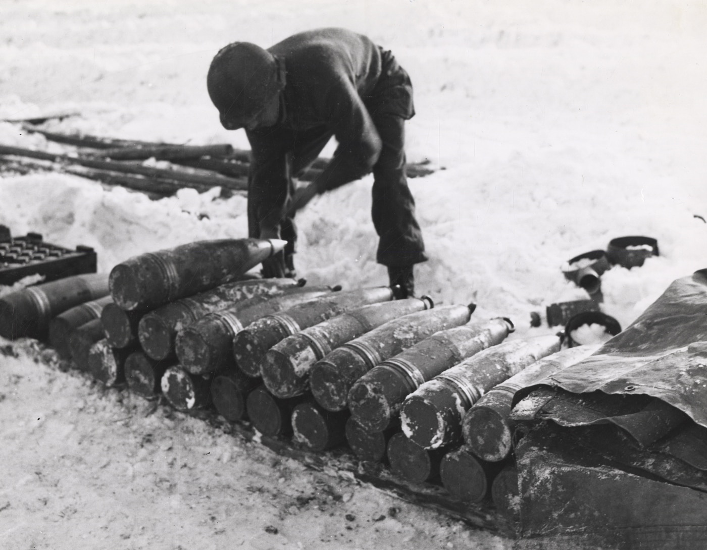 Cpl Edward Douglas places fuses in 155mm shells for M12 self-propelled artillery in Belgium