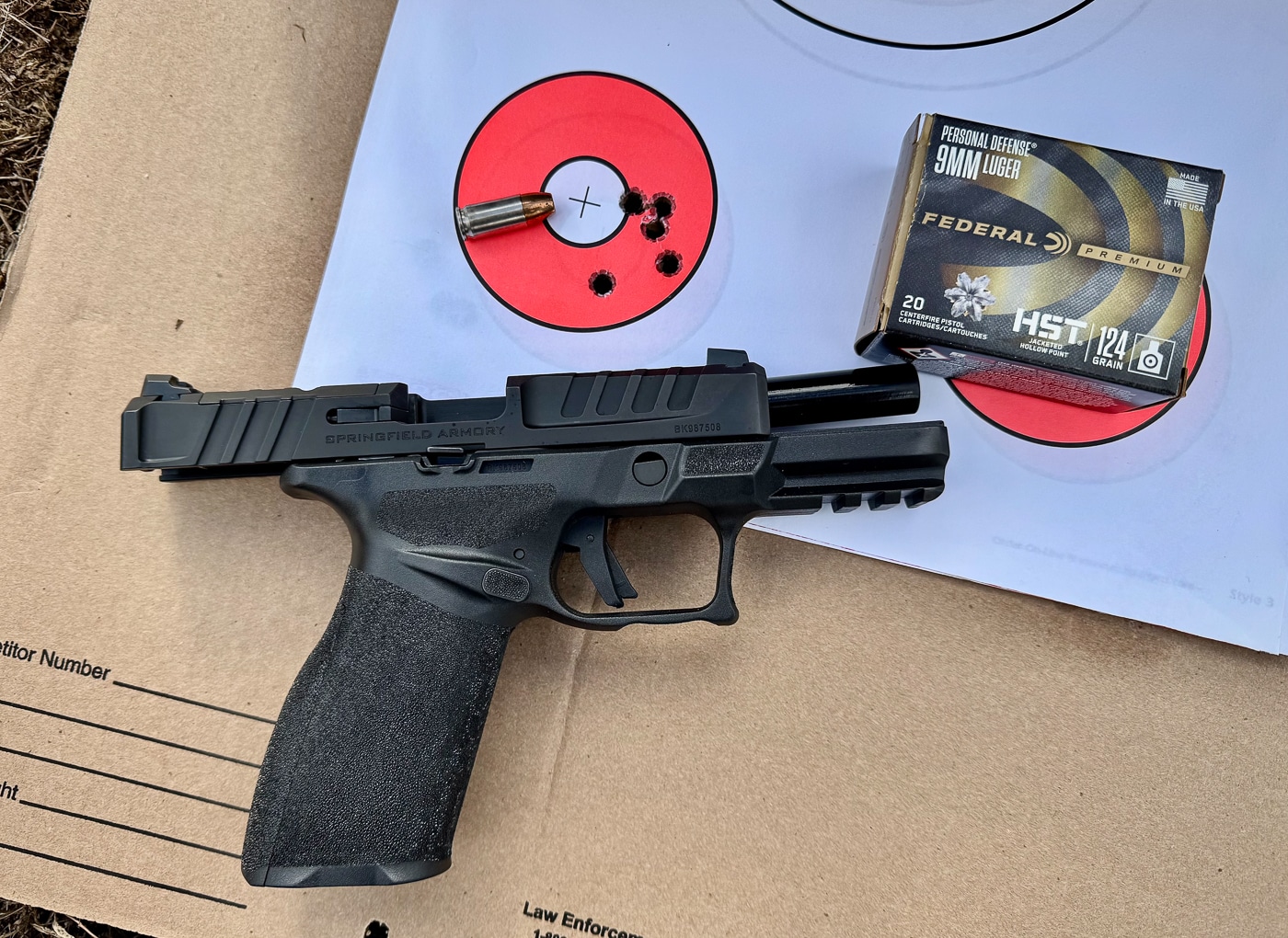 The Springfield Echelon 4.0FC pistol sits beside a paper target displaying tight bullet groupings from Federal HST ammunition testing. Springfield Echelon 4.0FC review documents defensive ammunition performance. Springfield Armory Echelon 4.0FC testing measures accuracy capabilities. Federal HST loads group tightly. Premium defensive rounds deliver consistent results. The barrel produces reliable velocities. Fifteen-yard groups demonstrate precision. Factory ammunition meets power factor requirements. Range testing validates carry reliability.