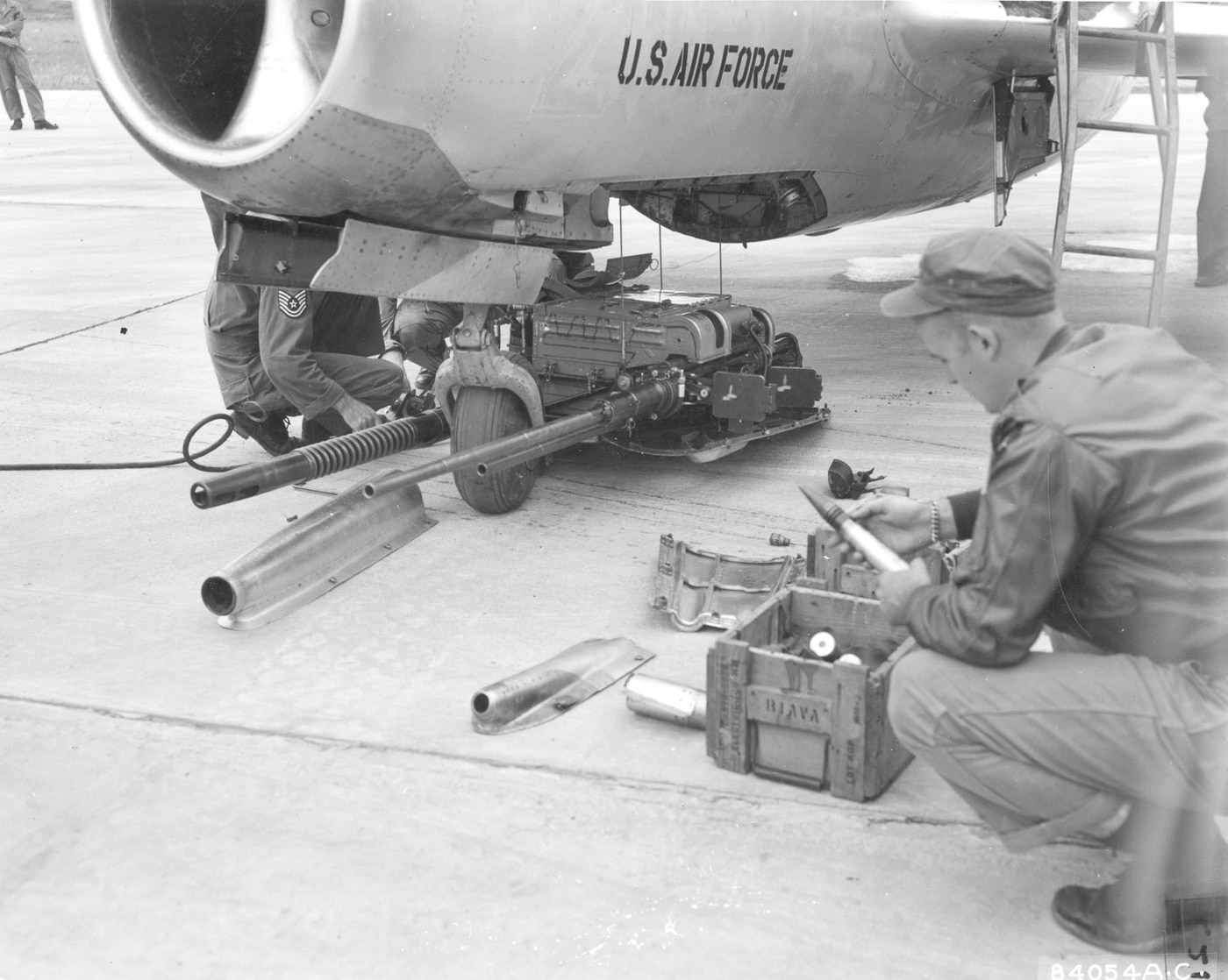US airman examines the three cannon section of the Mig-15 fighter