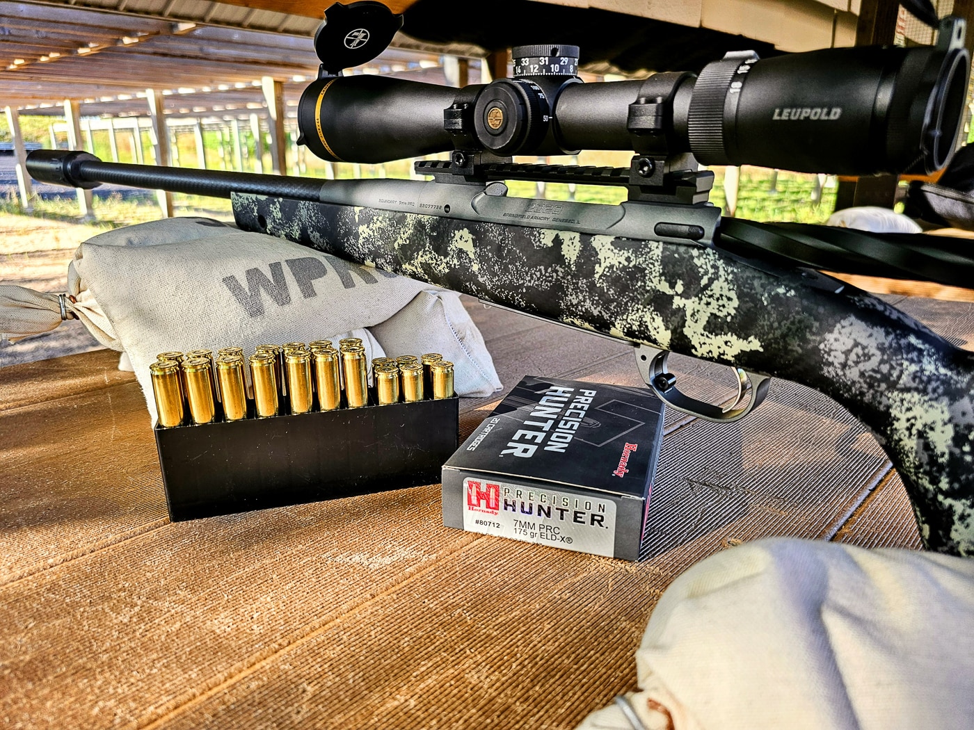 A Springfield Waypoint rifle sits secured in a bench rest with Hornady Precision Hunter ammunition boxes nearby during a sighting-in session. First hunting rifles need proper zeroing procedures. Beginner's hunting rifles perform best with quality ammunition. Premium hunting cartridges improve accuracy potential. Bench rest shooting eliminates human error variables. Hornady ammunition offers consistent performance. Range practice builds shooter confidence. Proper sight-in ensures ethical shots. Precision ammunition suits various game animals.