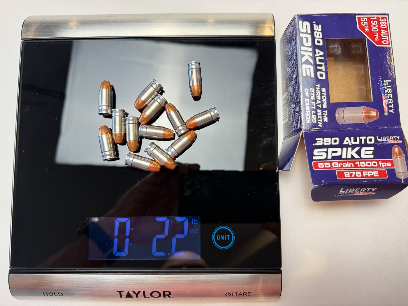 A scale weighing .380 ACP self-defense ammunition to demonstrate the weight differences between various defensive loads for concealed carry. Ammunition weight varies significantly across different .380 ACP self-defense rounds. Lighter defensive .380 ammunition reduces the overall carry weight of a loaded pistol. Traditional 90-grain hollow points weigh nearly twice as much as lightweight copper loads. Everyday concealed carry comfort depends partly on total loaded gun weight. All-copper bullets at 50 to 55 grains offer meaningful weight savings over standard loads. A full magazine of lightweight .380 ACP ammo can save over two ounces. Reduced carry weight encourages consistent daily concealed carry habits. Choosing the right self-defense cartridge means balancing ballistic performance with practical comfort.
