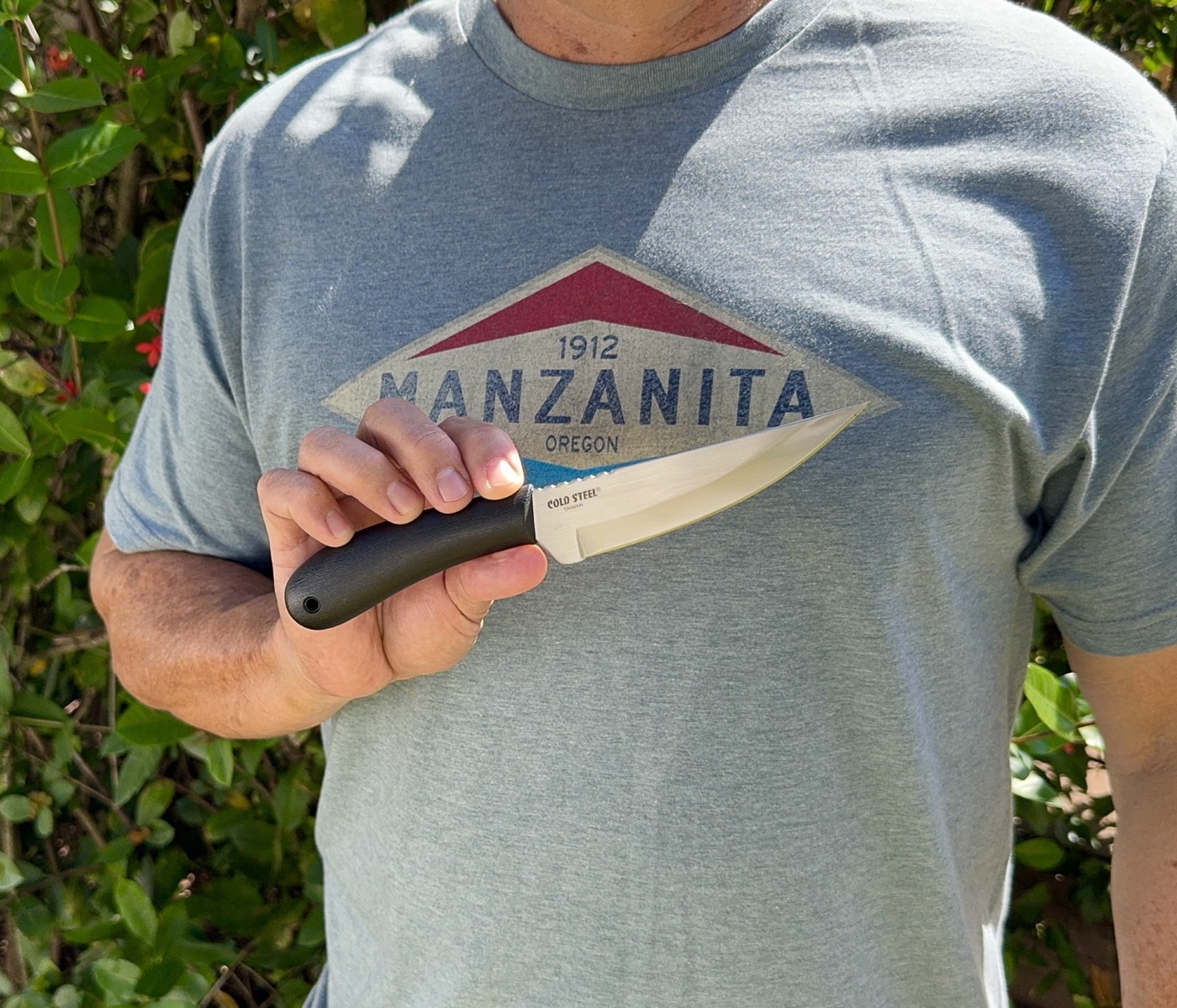 author holding the Roach Belly knife for the camera so we can see the details of the design