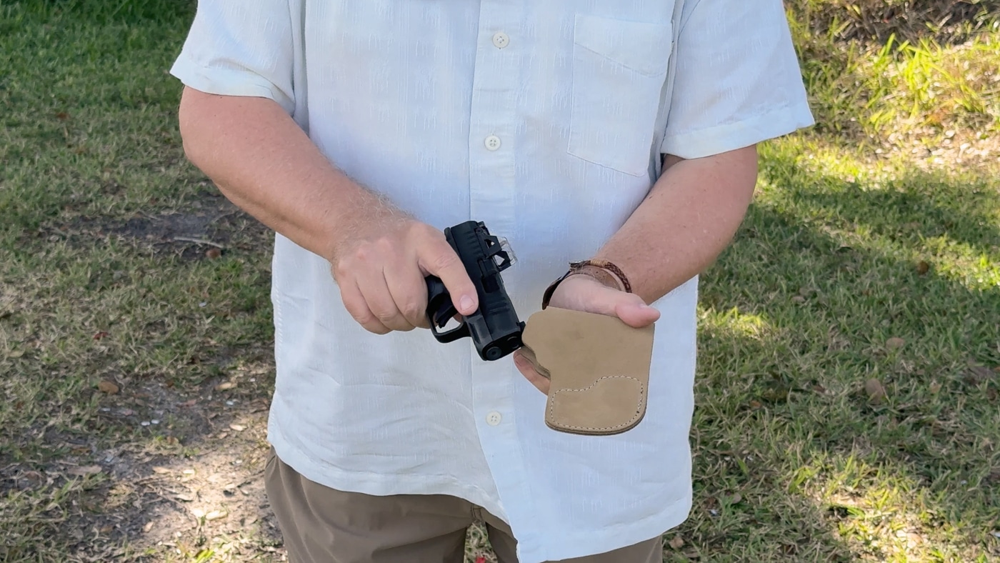 author showing his Hellcat 380 with a leather pocket holster