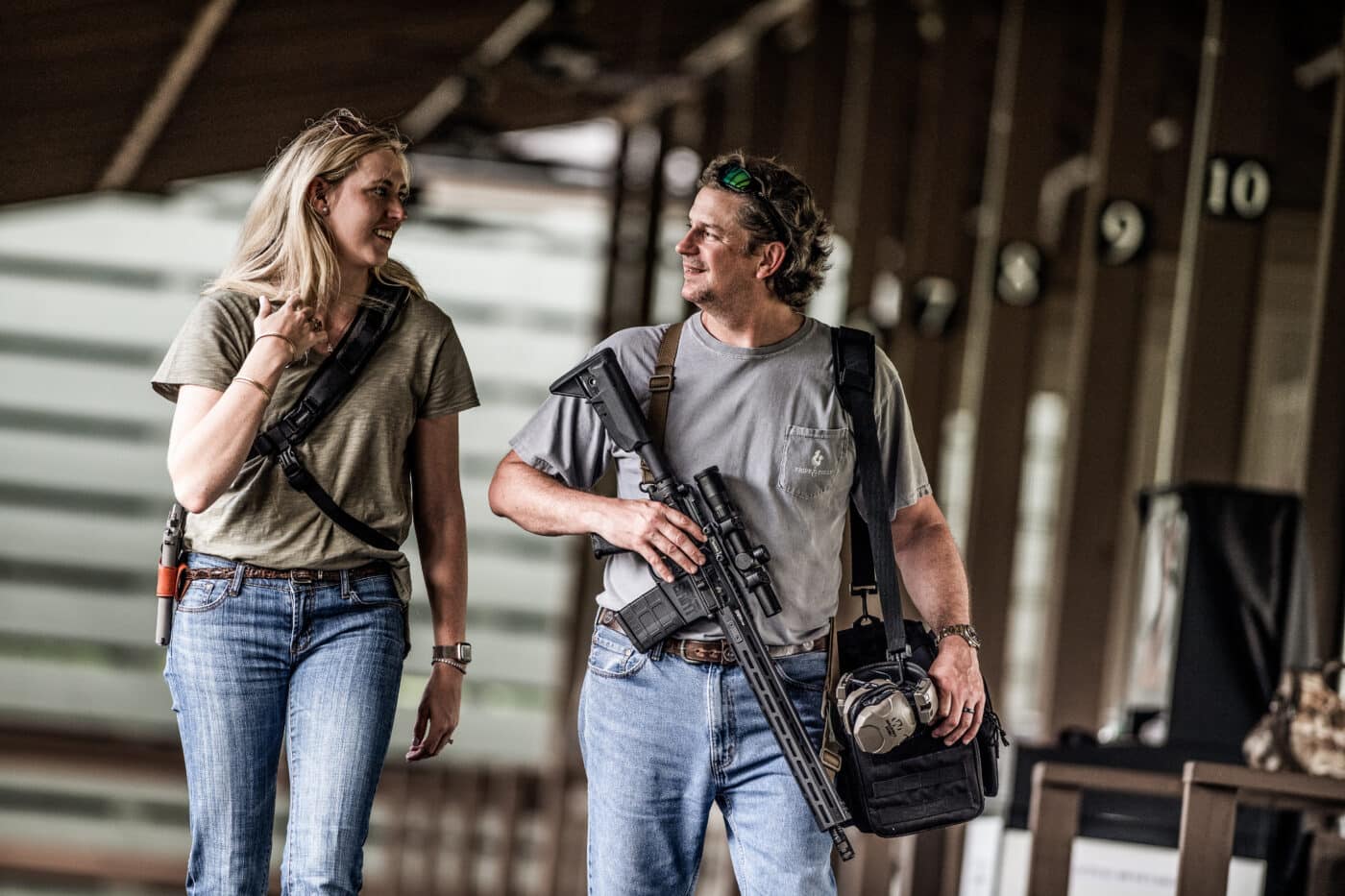 A man and woman stand together at a gun counter, examining an AR-15 rifle as they consider their first home defense firearm purchase. The best AR-15 for beginners balances ease of use with reliable performance. Entry-level AR-15 rifles are widely available from trusted manufacturers. New shooters benefit from the AR-15's straightforward manual of arms. Beginner-friendly rifles often feature adjustable stocks and low felt recoil. The AR-15 platform offers modular components suited to first-time gun owners. Home defense rifles should be easy to operate under stress. Starter AR-15 models provide quality construction without an intimidating price point. Couples and first-time buyers are increasingly drawn to the AR-15 as their go-to home protection firearm.