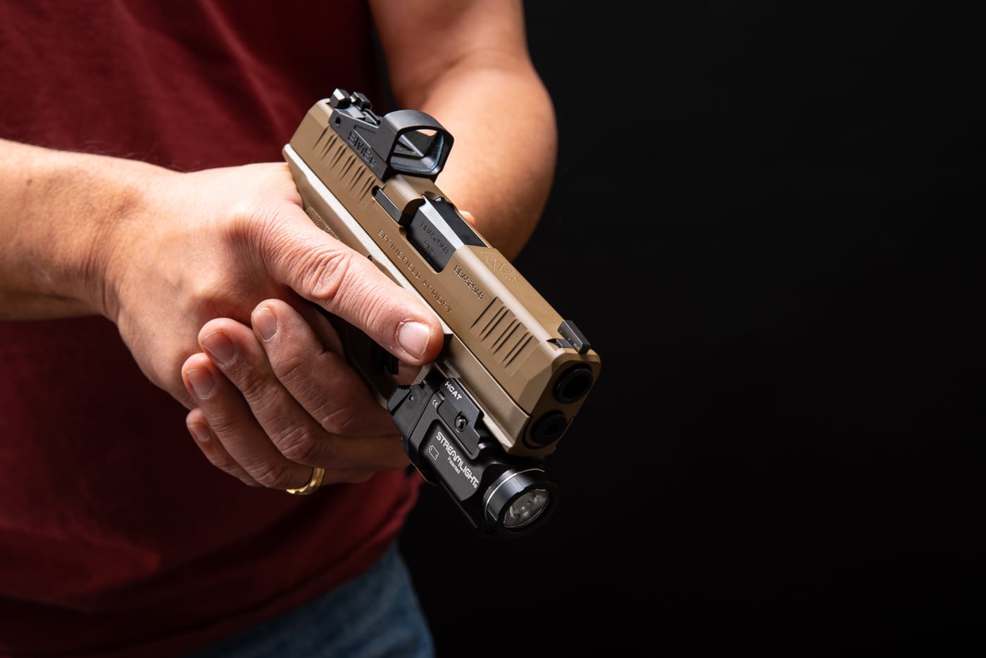 man holding a Springfield Armory Hellcat FDE at low ready during training on the shooting range