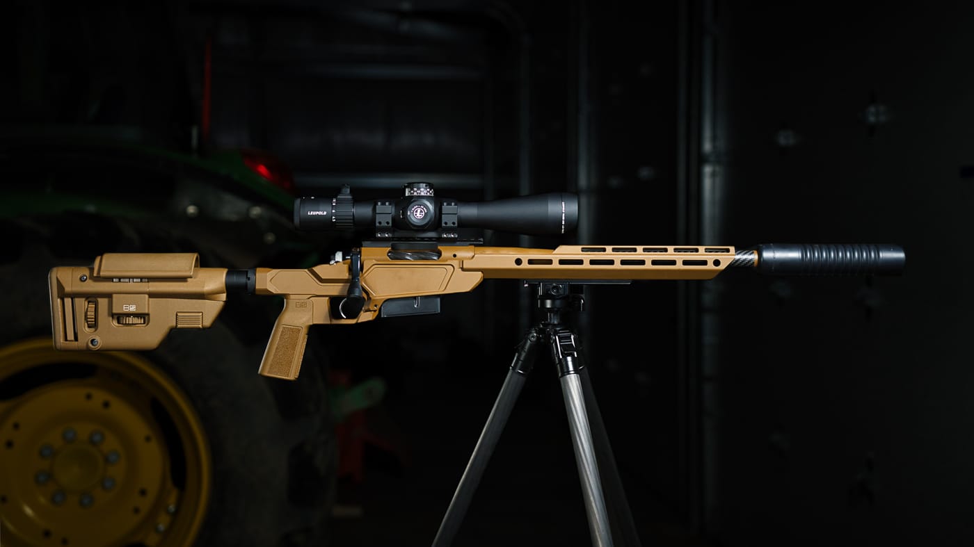 scope mounted on rifle and attached to a tripod