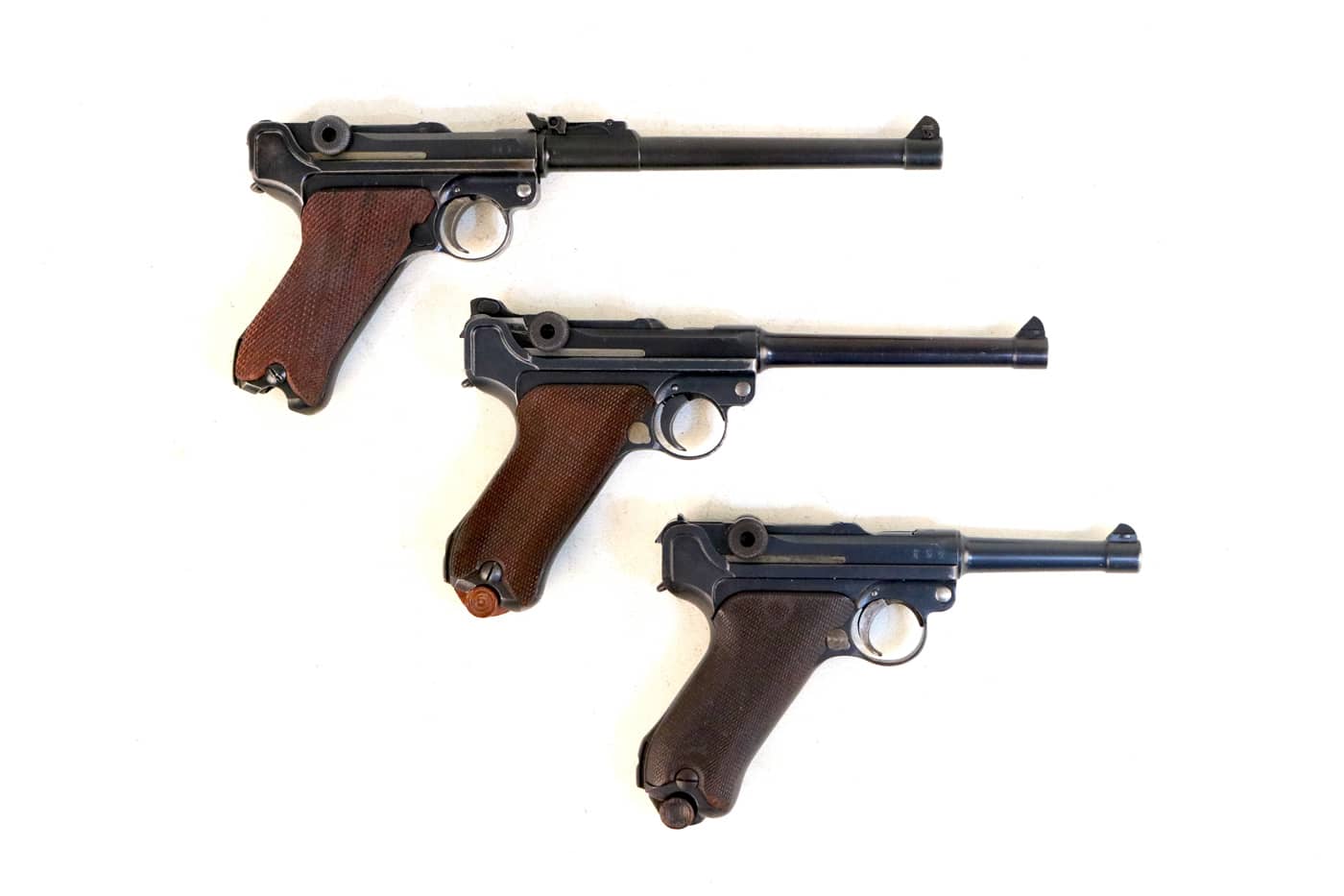 three P08 Luger pistols displayed to show the barrel lengths