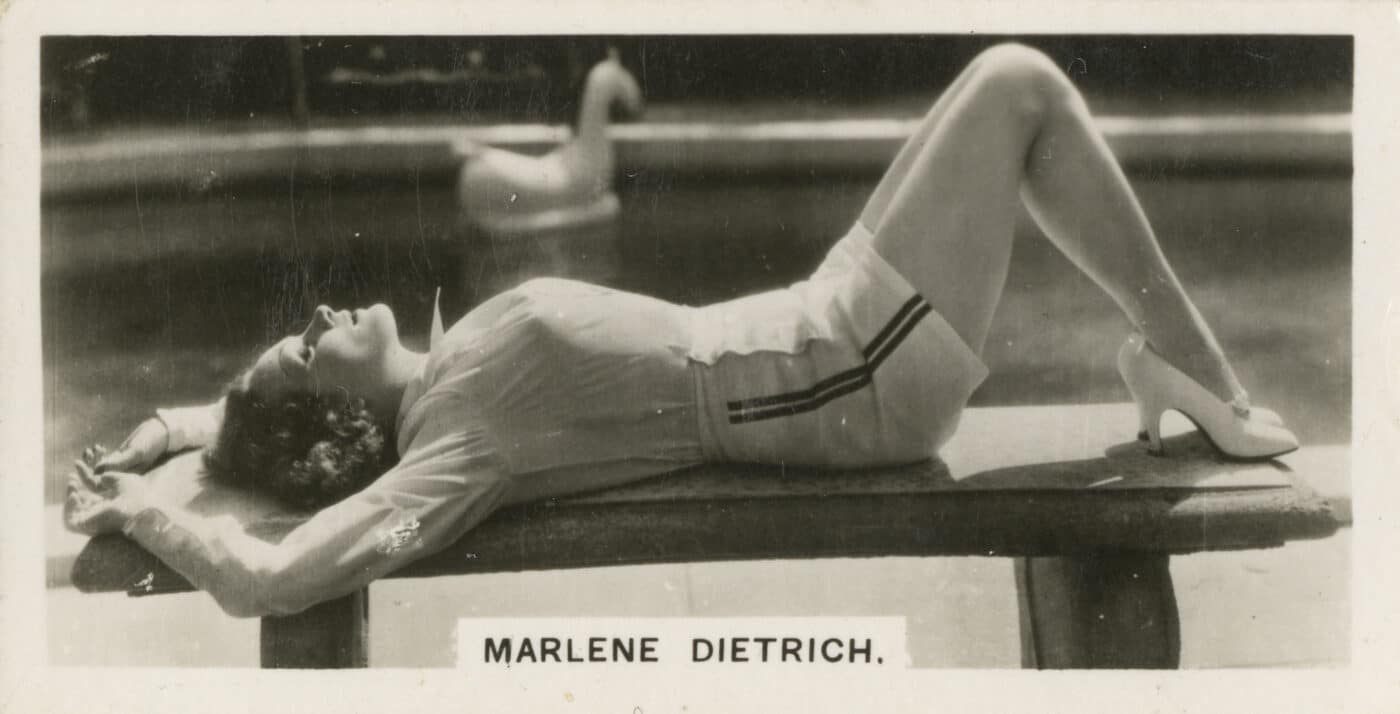 Marlene Dietrich with high heels lying on outdoor bench