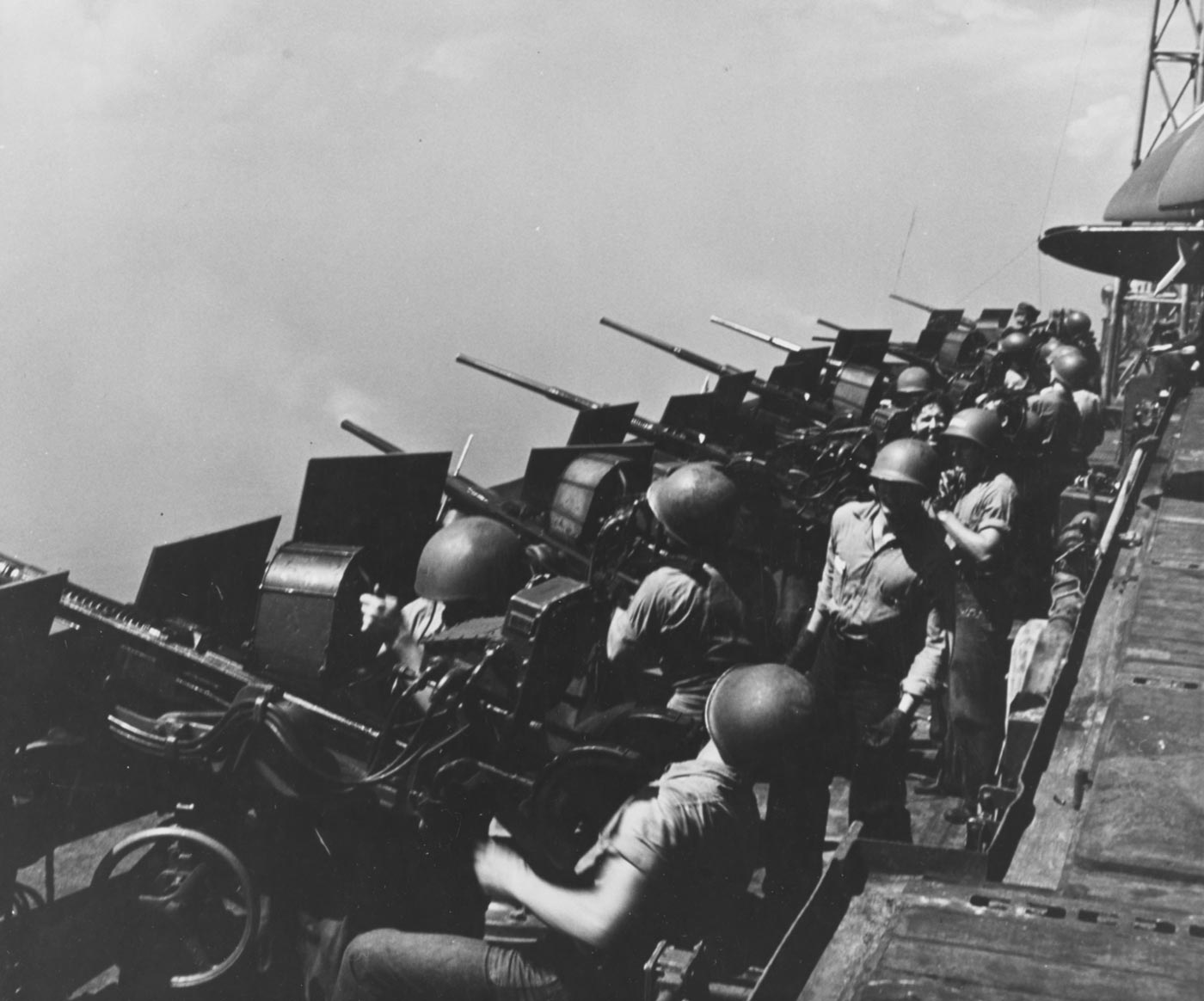 US Navy sailors man Oerlikon 20mm cannons on USS Hornet during operations off Japan