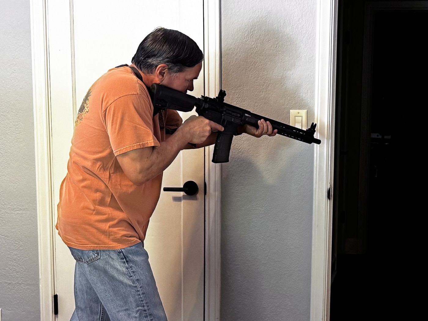 author with rifle clearing a home