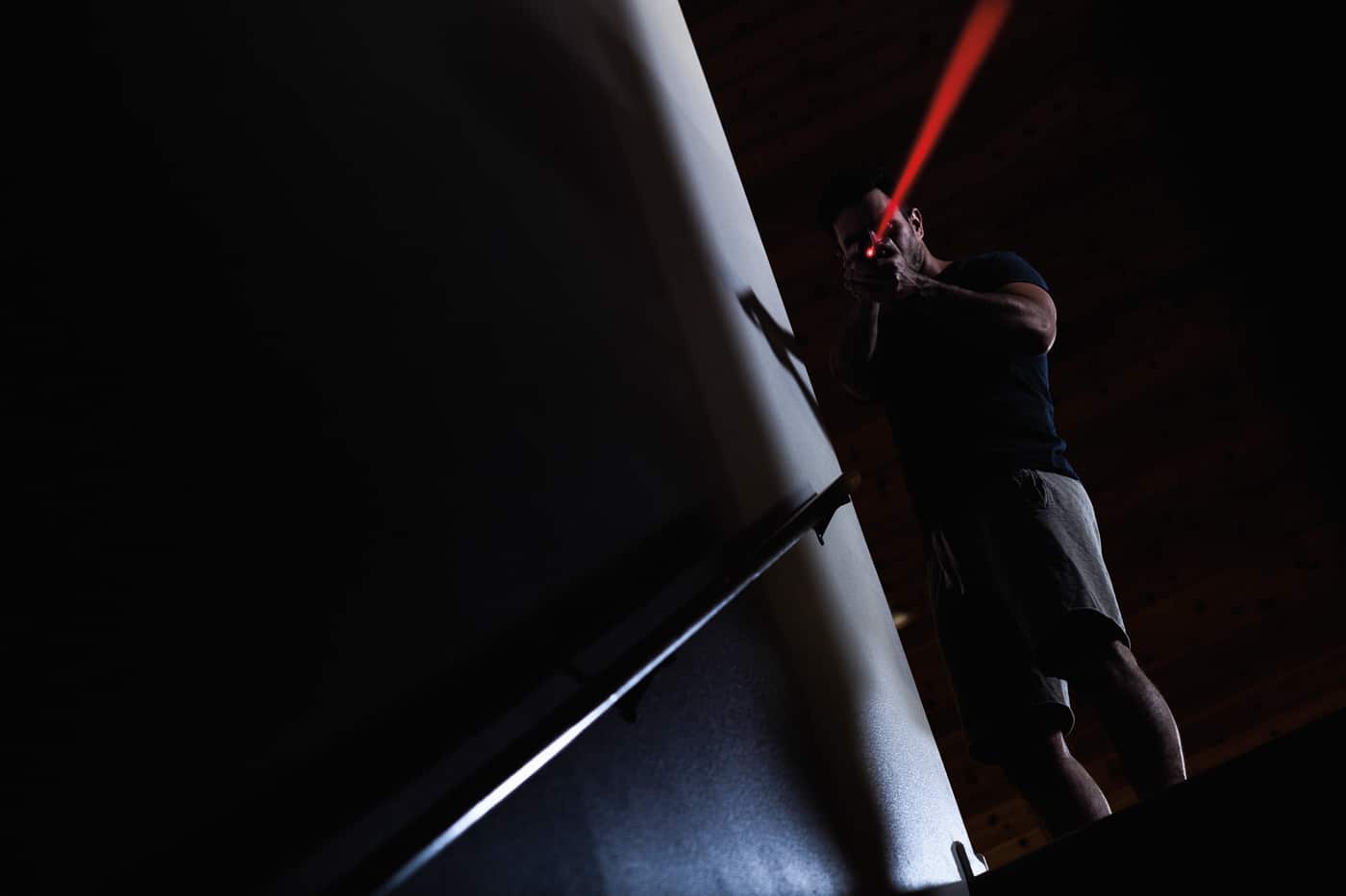 man with Springfield Armory pistol and mounted laser in home defense