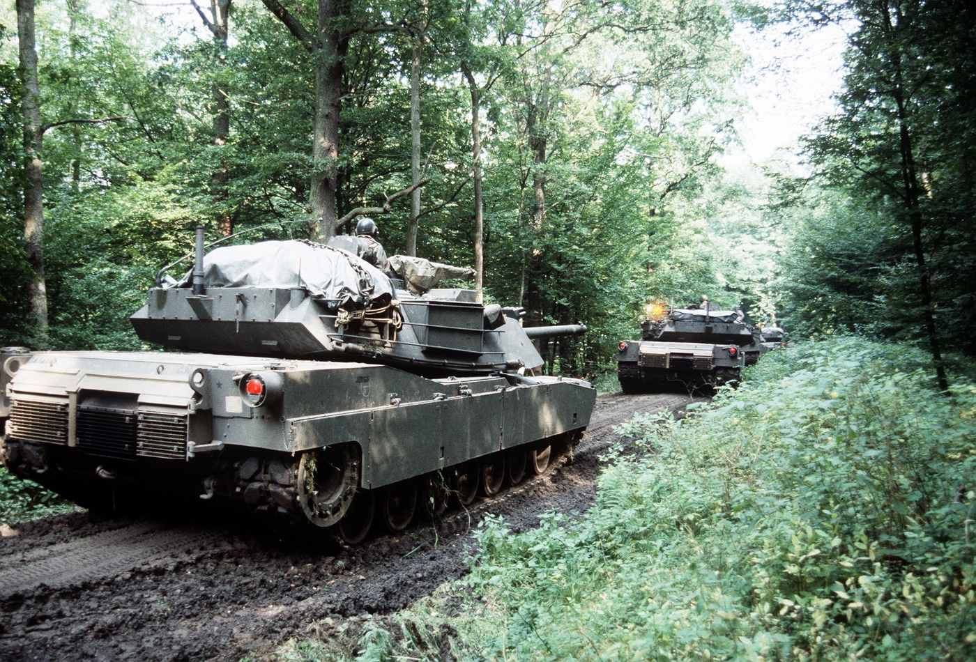 M1 Abrams tanks move through West German forest during REFORGER 85