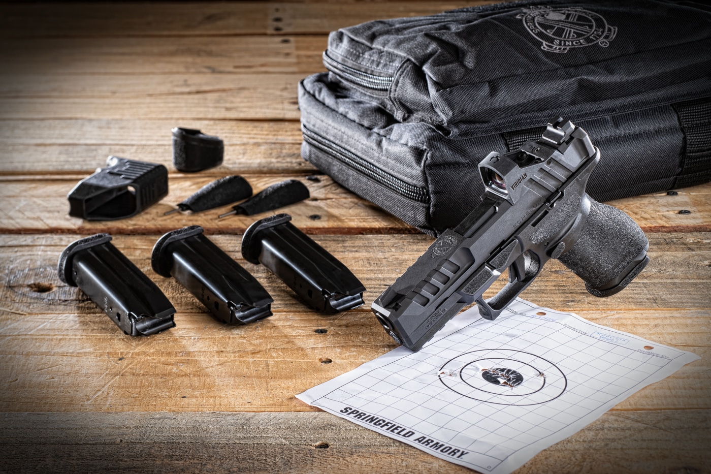 Photo displays the complete contents of a Springfield Echelon Gear Pac including the pistol, soft case, four magazines, and a Viridian RFX-11 green dot optic arranged together. The Echelon Gear Pac bundles essential pistol accessories. Springfield Armory designs the Gear Pac for new pistol owners. The Springfield Armory Echelon deal includes a factory-installed red dot. Shooters need multiple magazines for range practice. The Viridian RFX-11 mounts directly to the Echelon slide. Pistol bundles save buyers money on accessories. The Springfield Armory Echelon deal eliminates aftermarket shopping. Gun owners appreciate complete pistol packages.